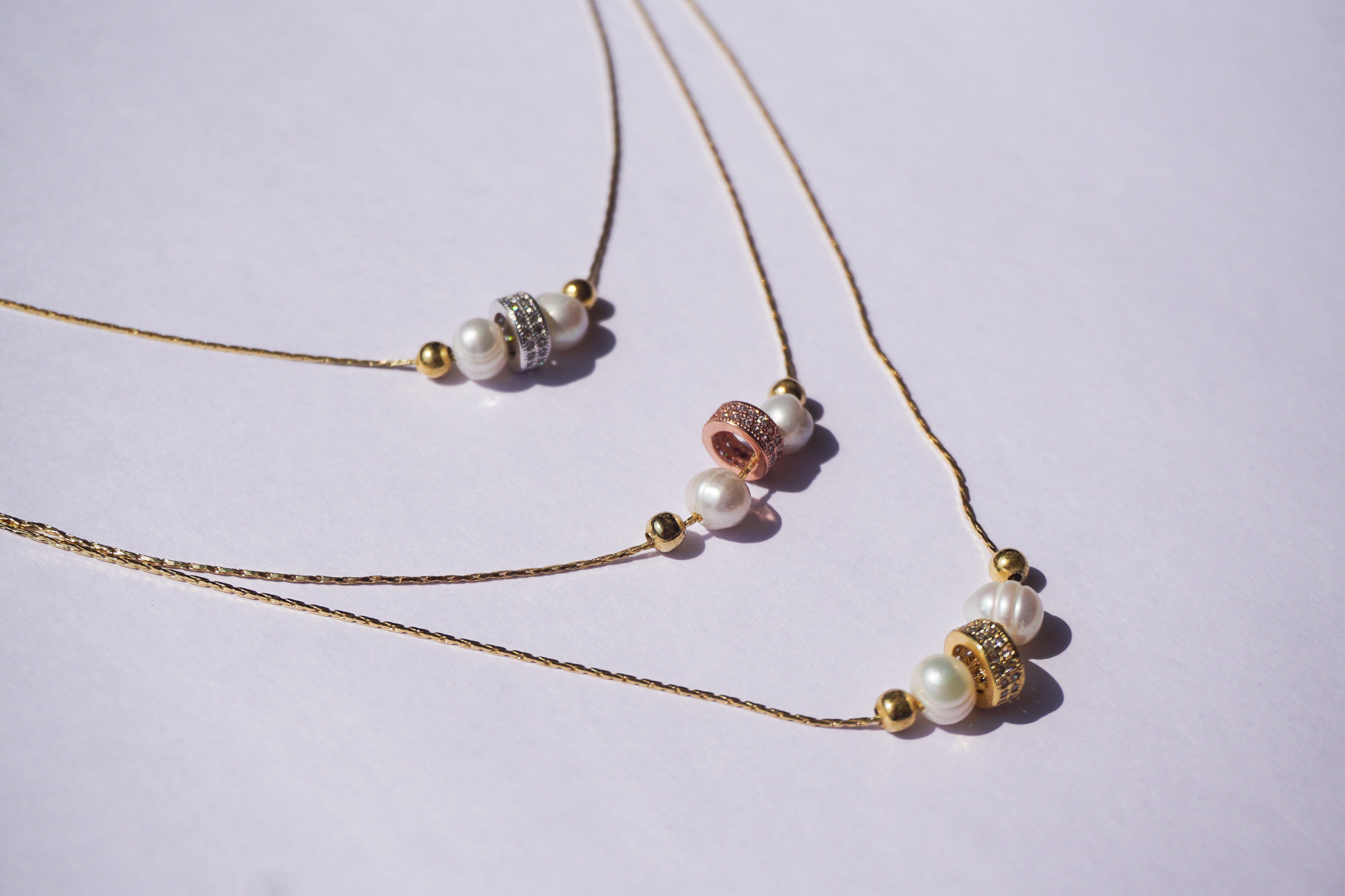 Gargantilla dorada de tres hilos con 3 barrilitos con zirconias y perlita natural intercalada