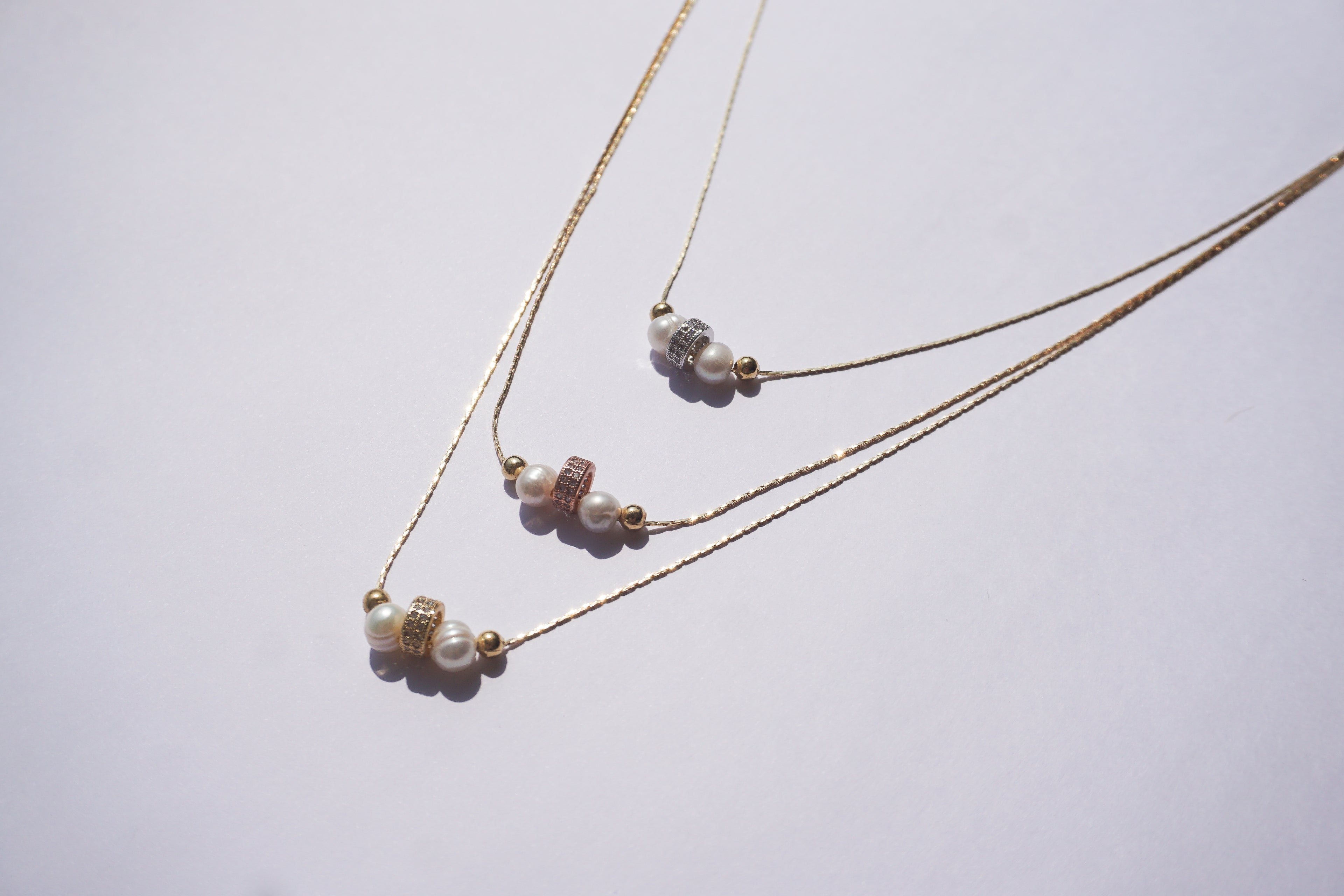 Gargantilla dorada de tres hilos con 3 barrilitos con zirconias y perlita natural intercalada