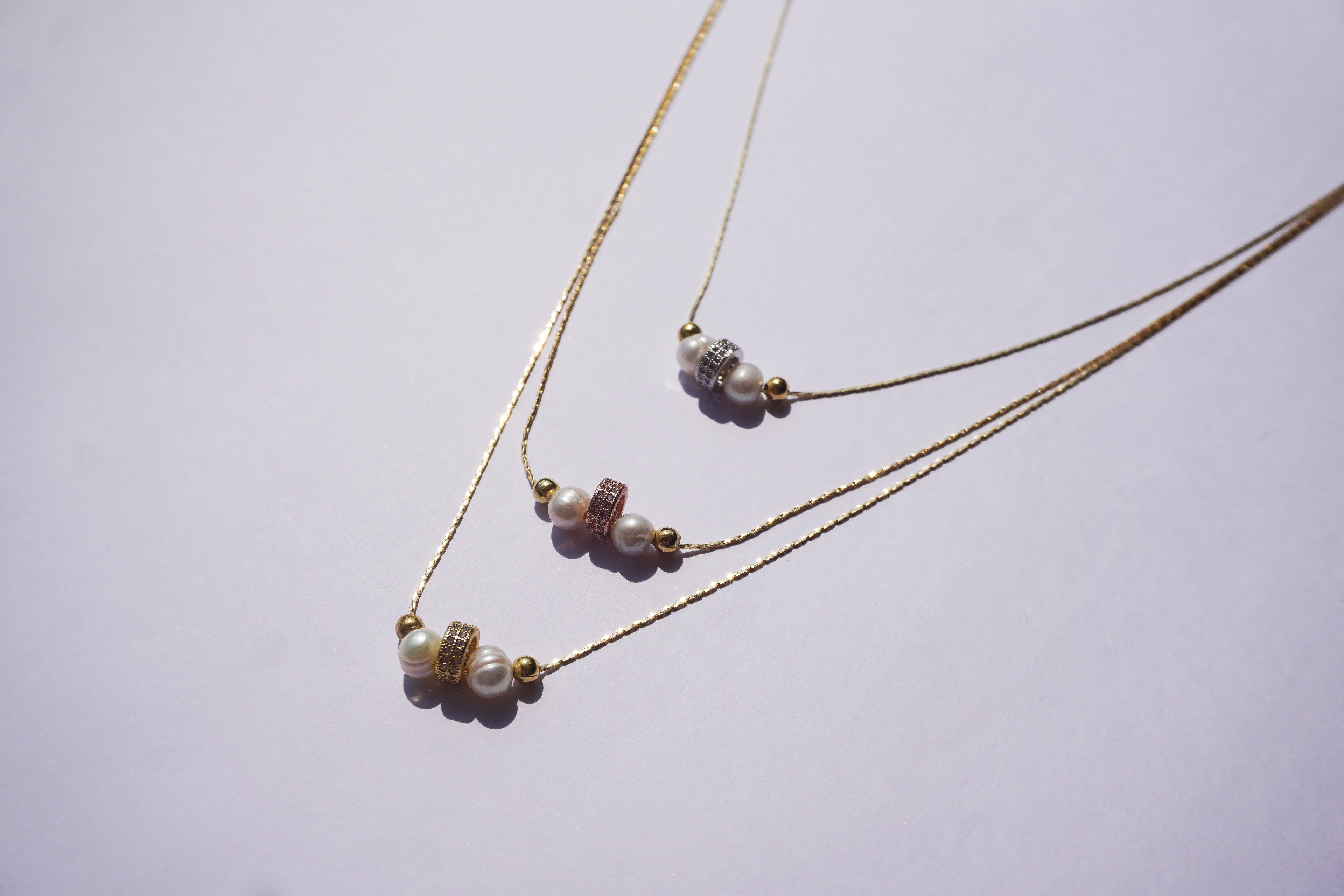 Gargantilla dorada de tres hilos con 3 barrilitos con zirconias y perlita natural intercalada