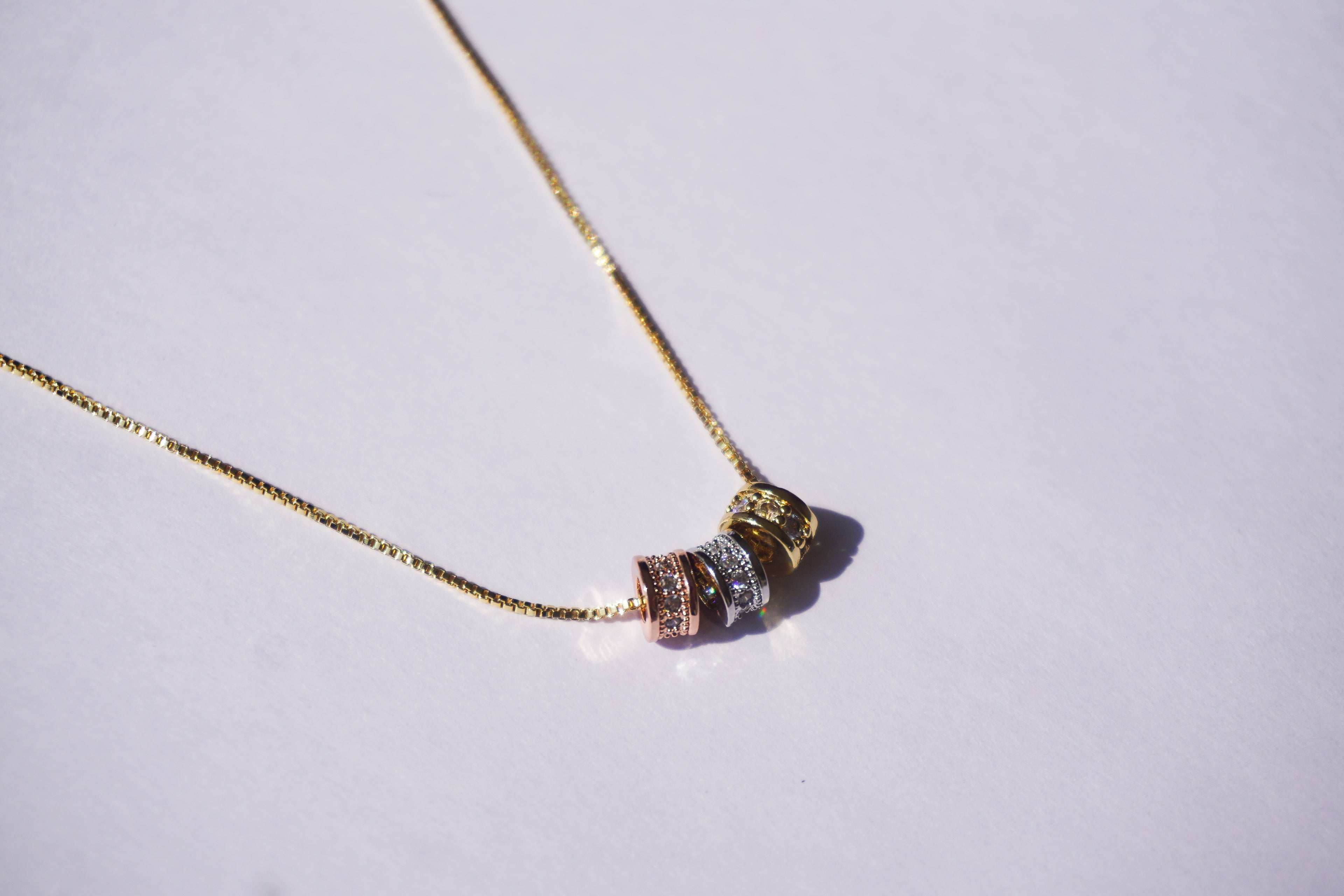 Gargantilla dorada con 3 barrilitos con zirconias