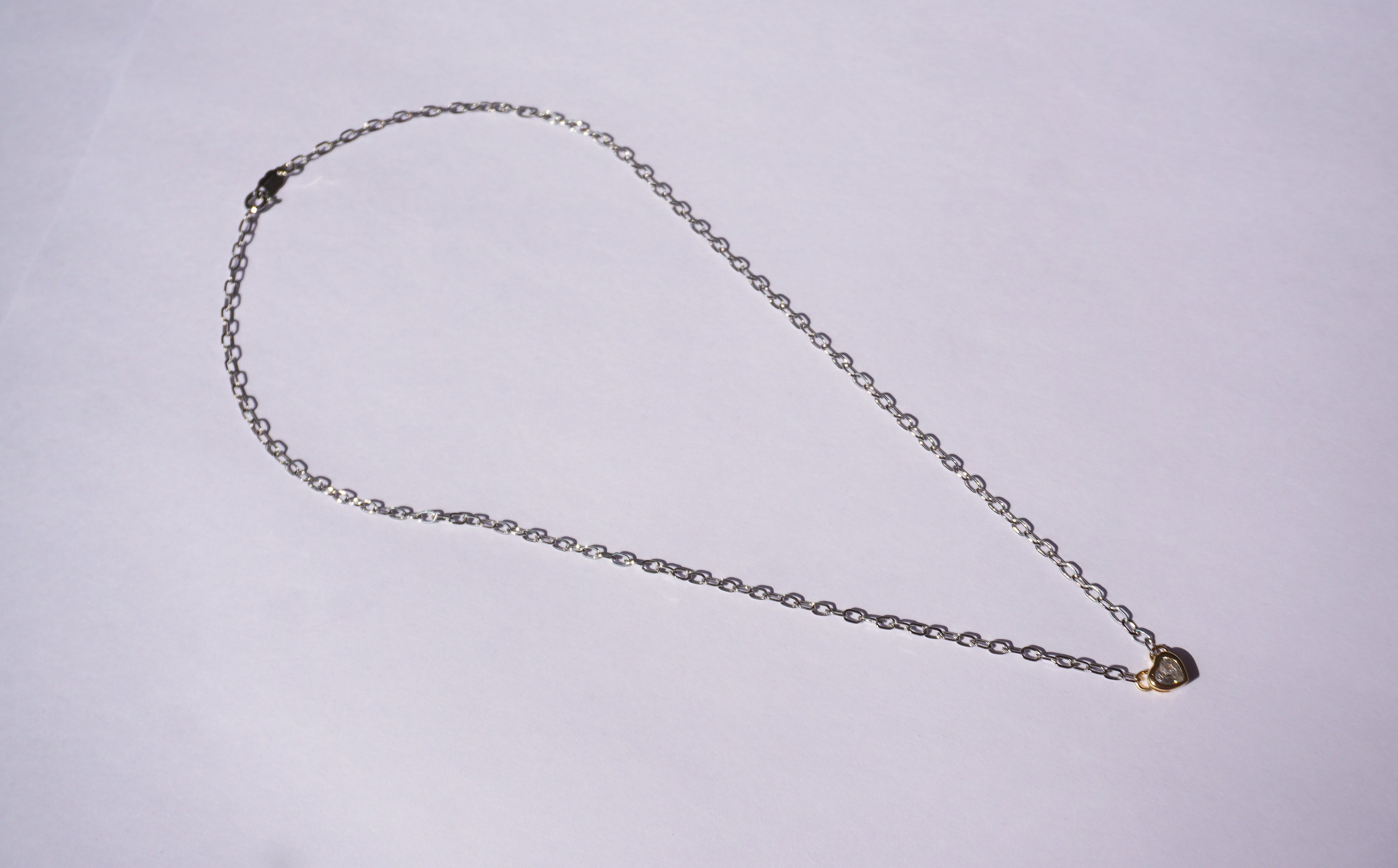 Collar de cadena plateada con corazón dorado