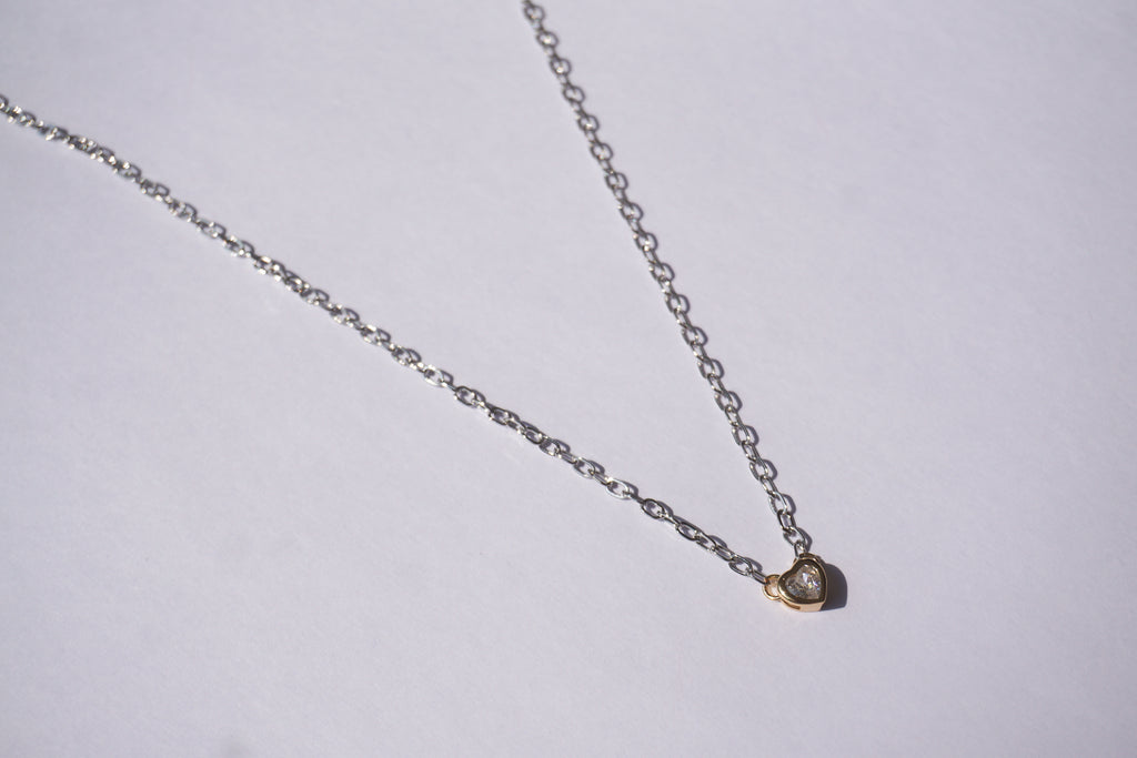 Collar de cadena plateada con corazón dorado