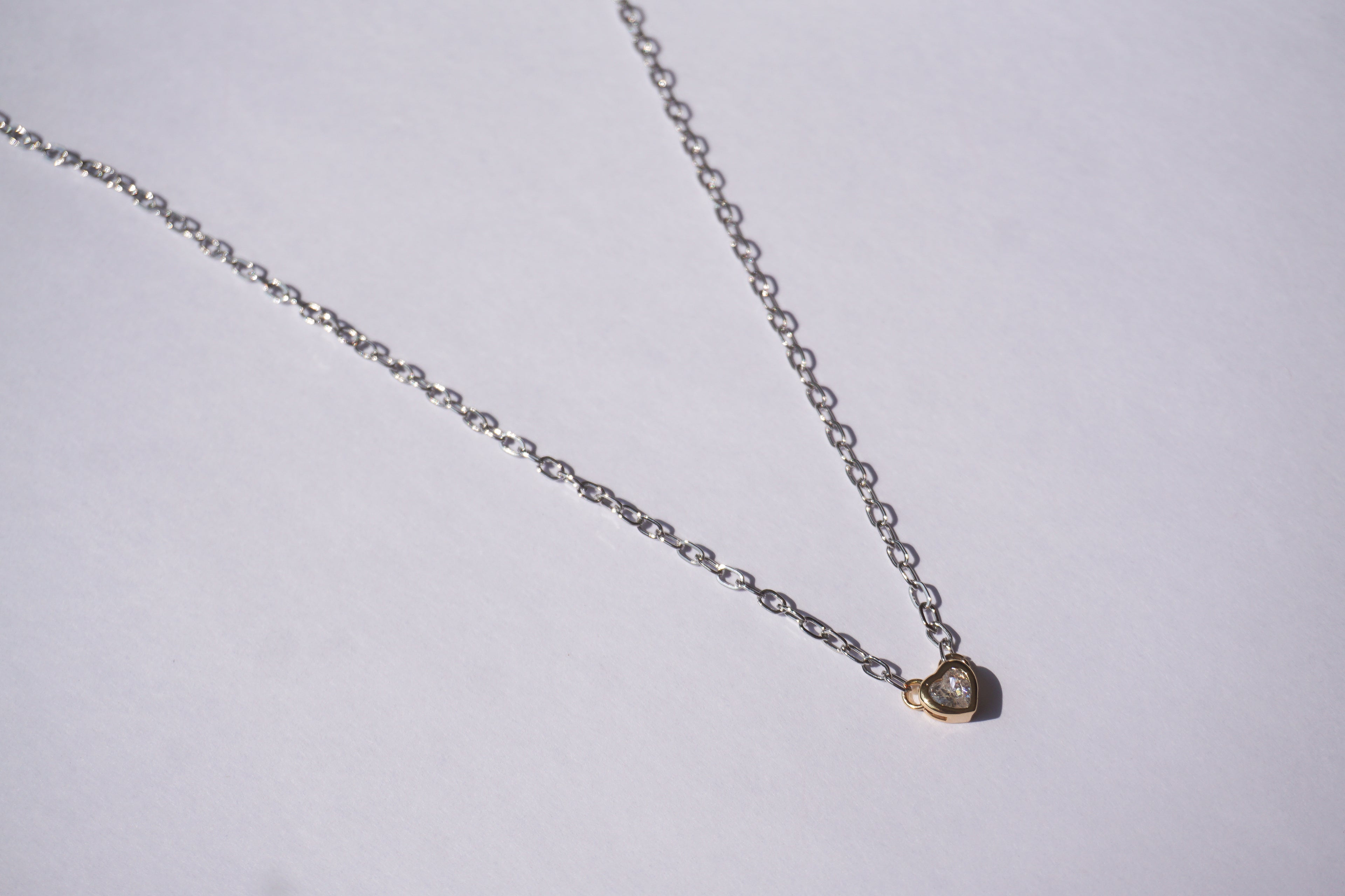 Collar de cadena plateada con corazón dorado