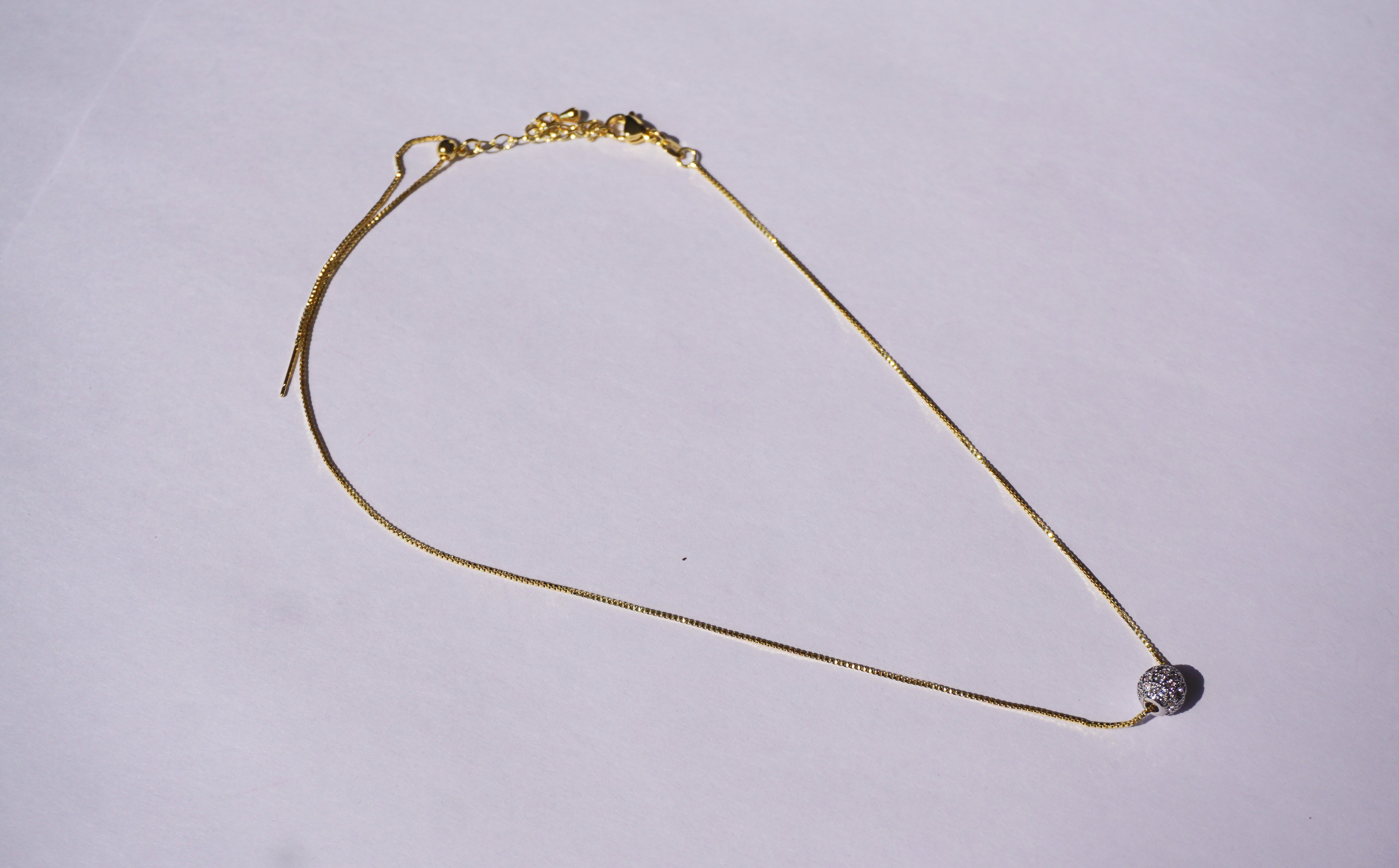 Collar con cadena dorada y bolitas de zirconias plateada