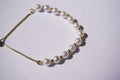 Pulsera perlas con bolita dorada