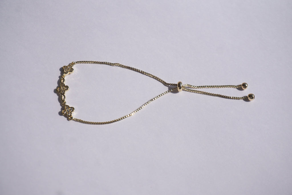 Pulsera dorada con broche ajustable con tréboles