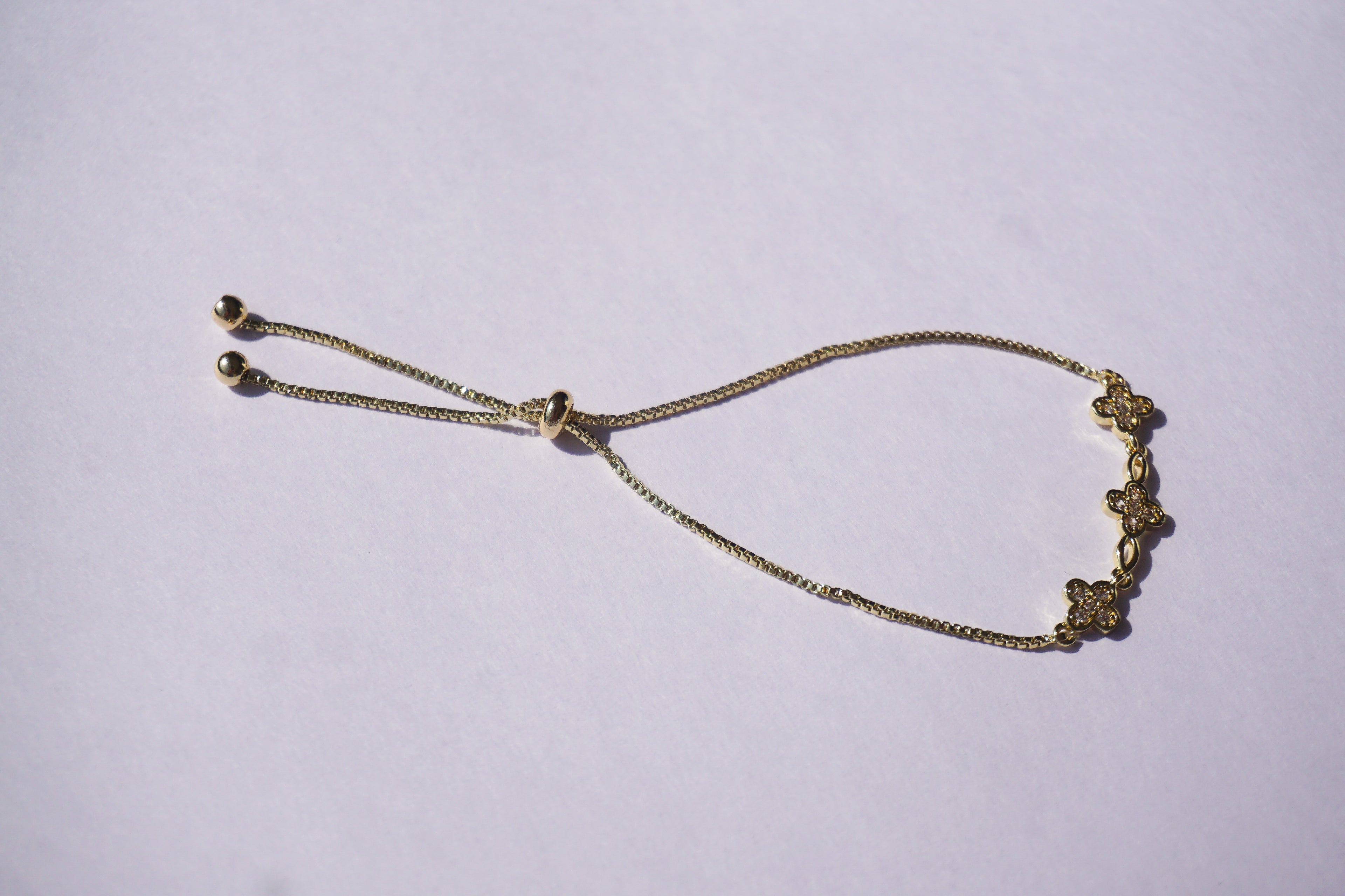 Pulsera dorada con broche ajustable con tréboles