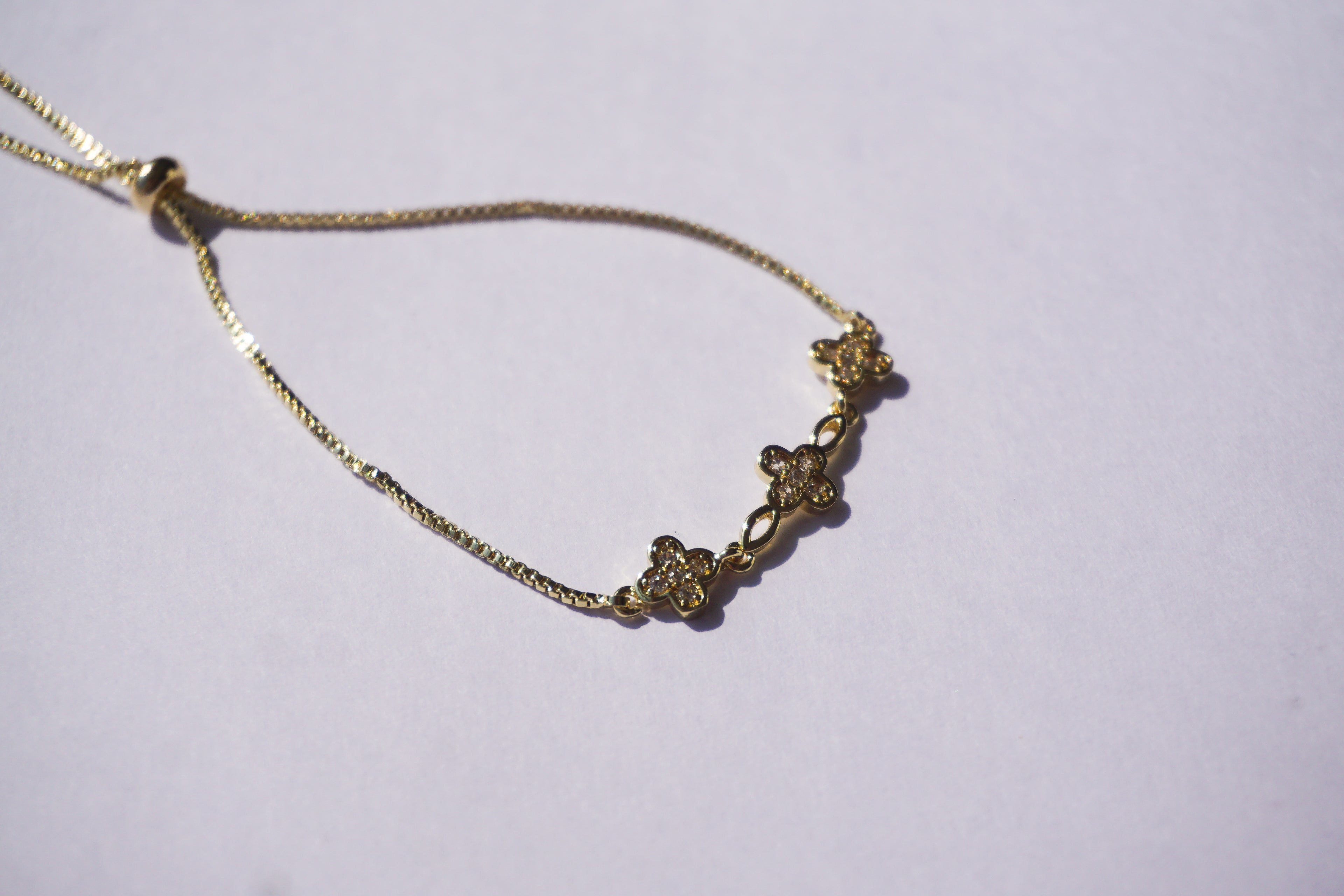 Pulsera dorada con broche ajustable con tréboles