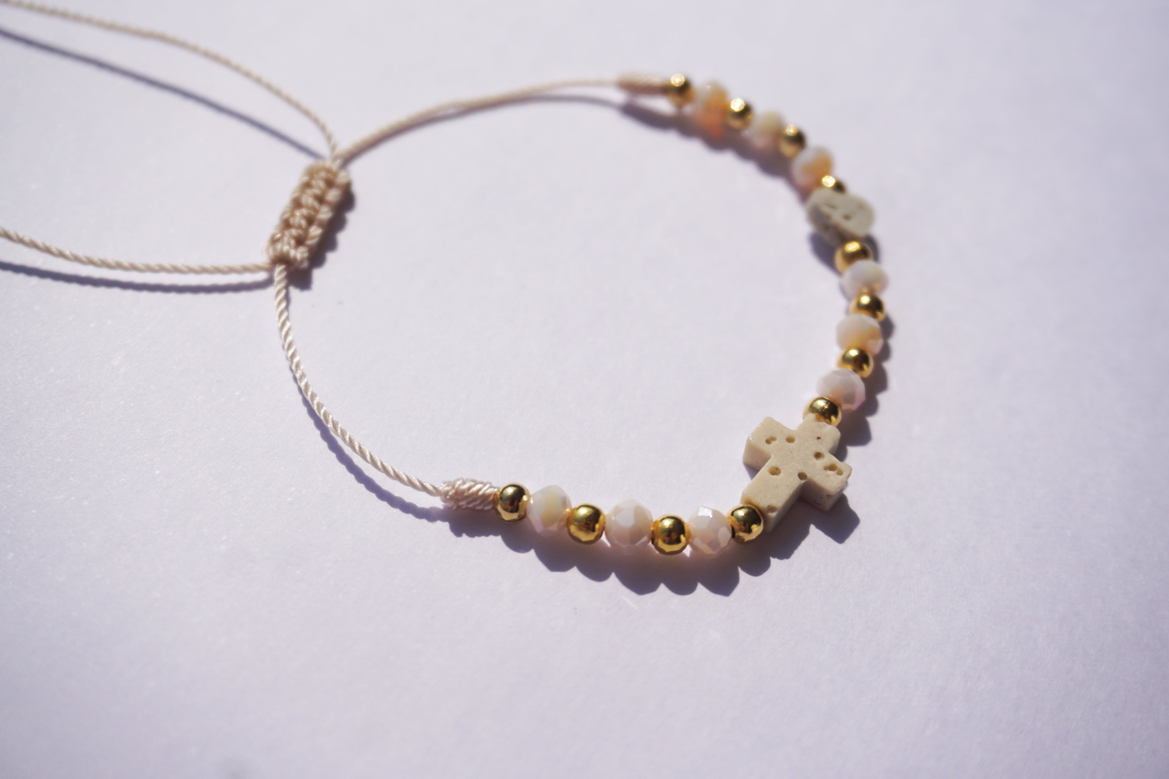 Pulsera de hilo con piedra de cristal y bolita dorada