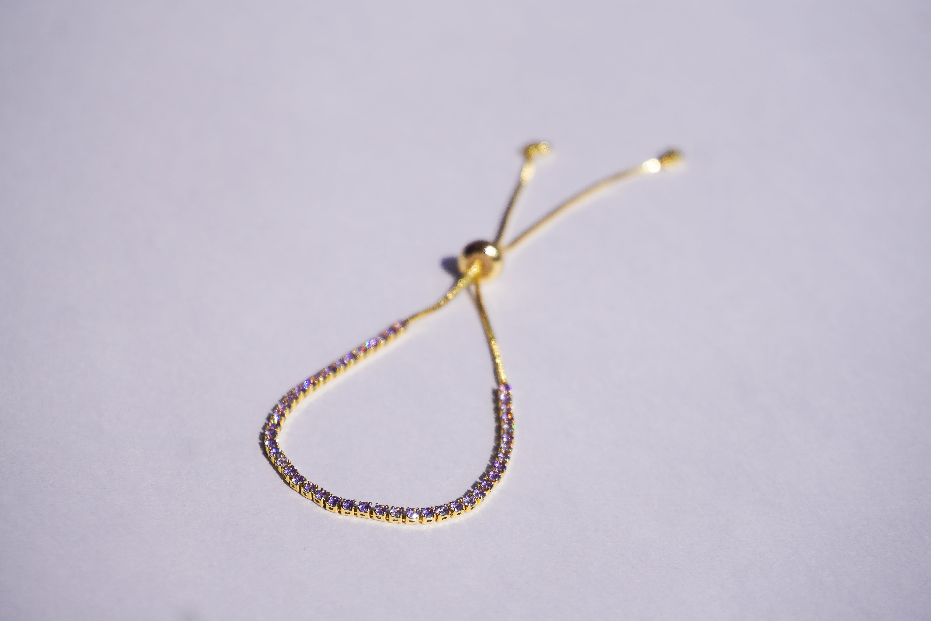 Pulsera tennis dorada con zirconias lilas