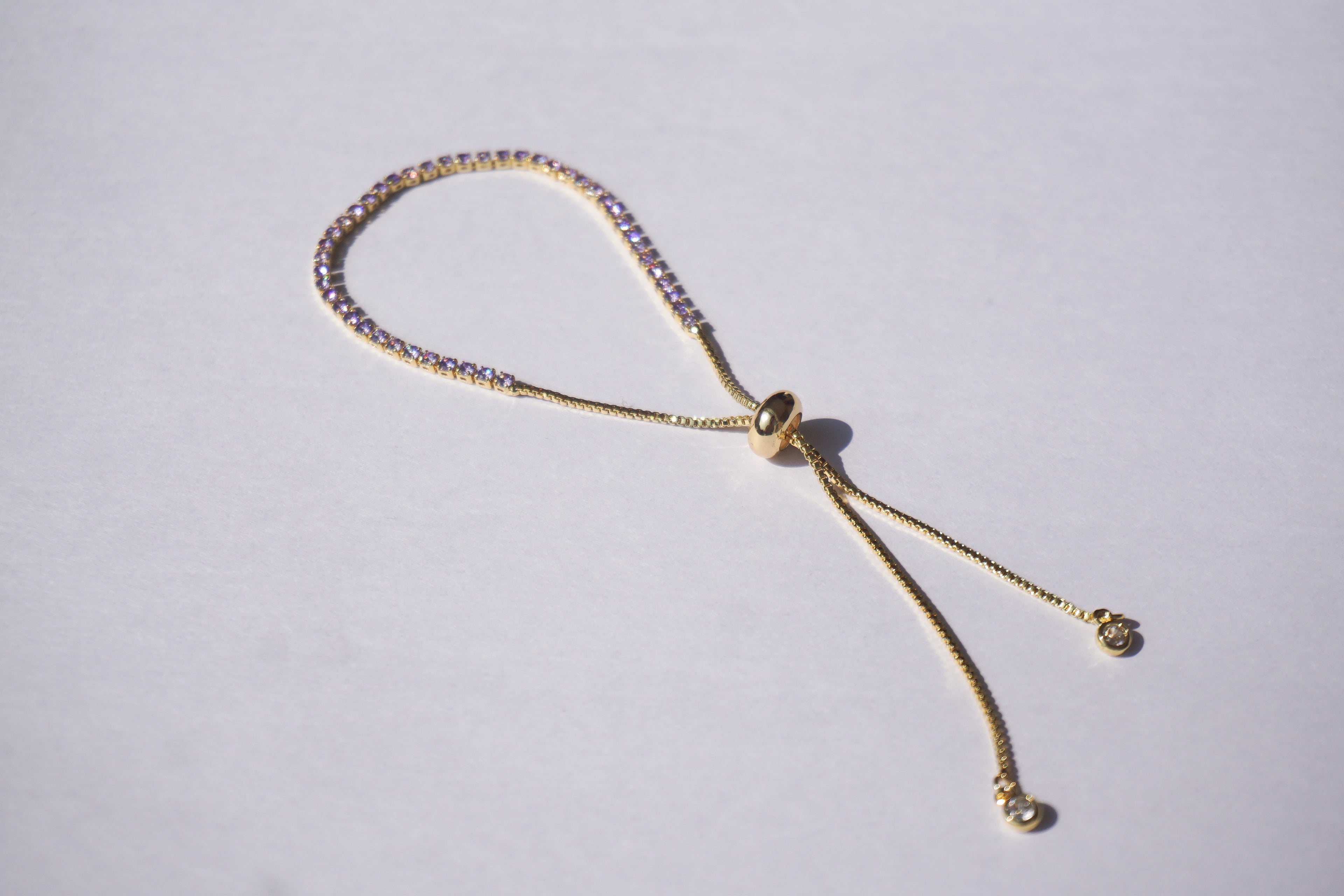 Pulsera tennis dorada con zirconias lilas
