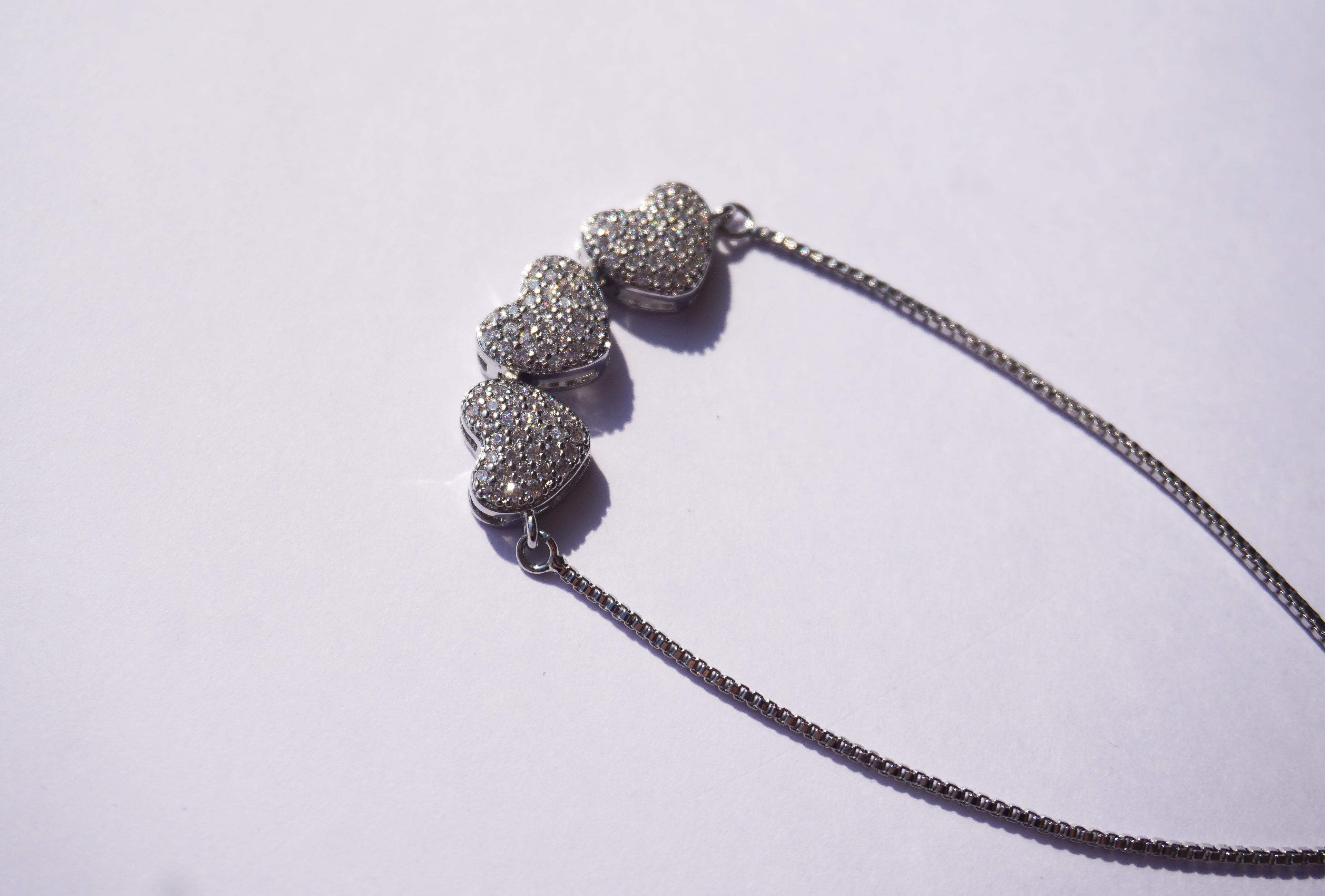 Pulsera plateada con broche ajustable con 3 corazones con zirconias