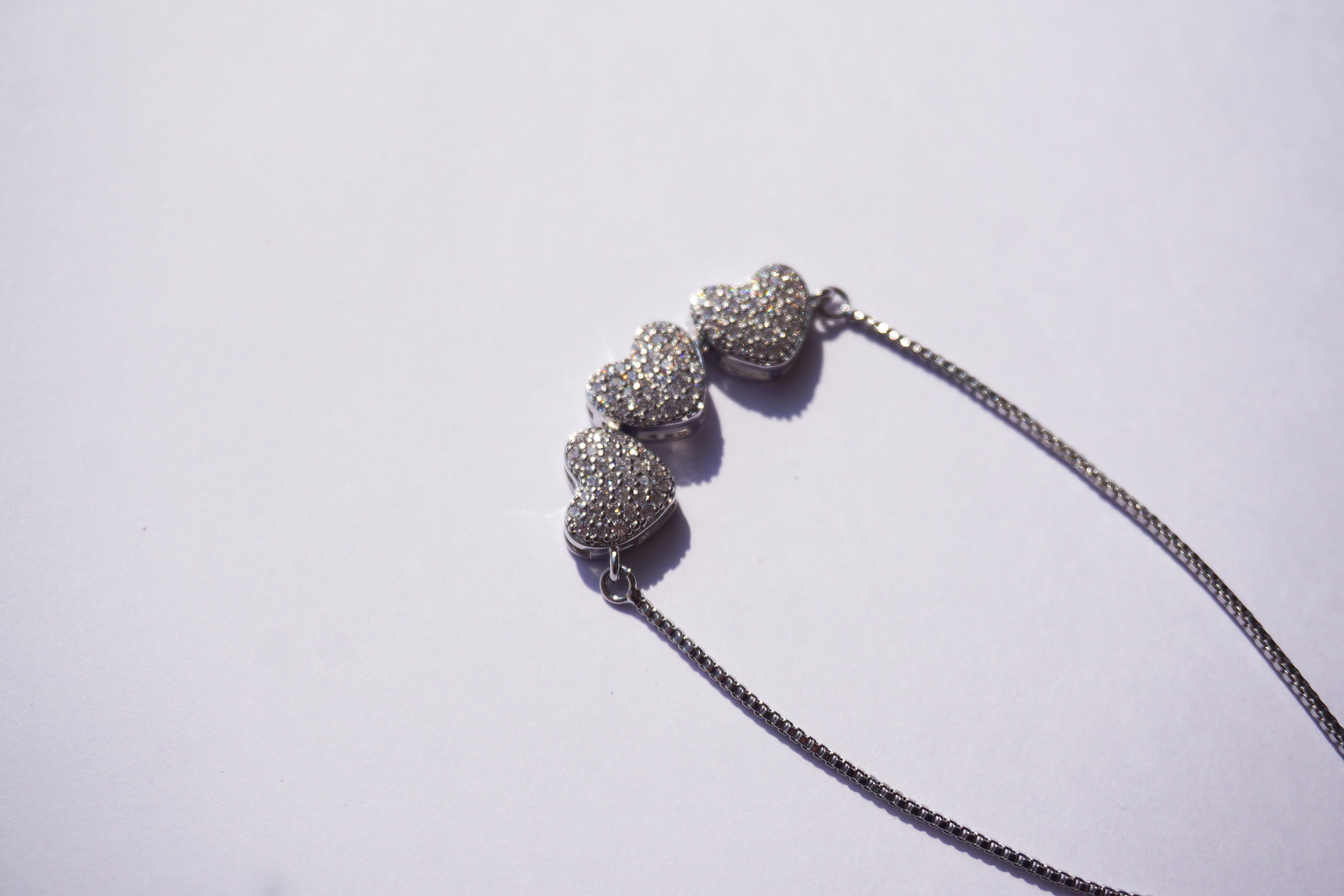 Pulsera plateada con broche ajustable con 3 corazones con zirconias