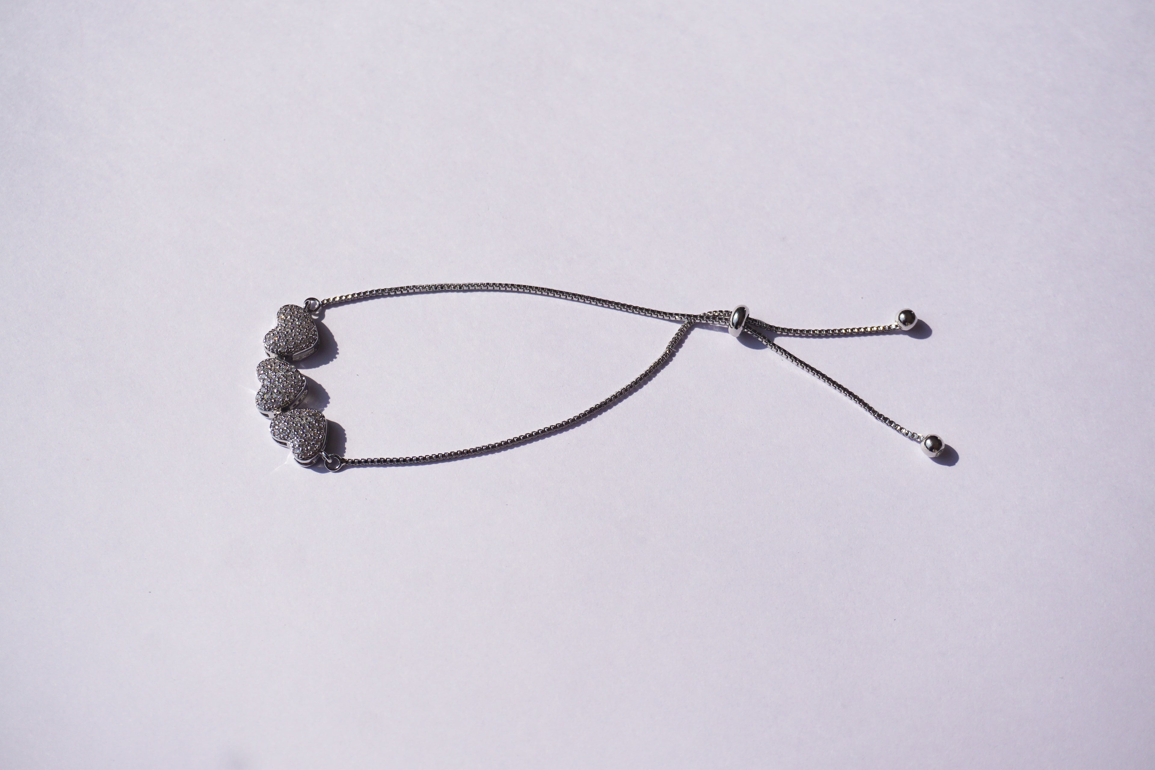 Pulsera plateada con broche ajustable con 3 corazones con zirconias