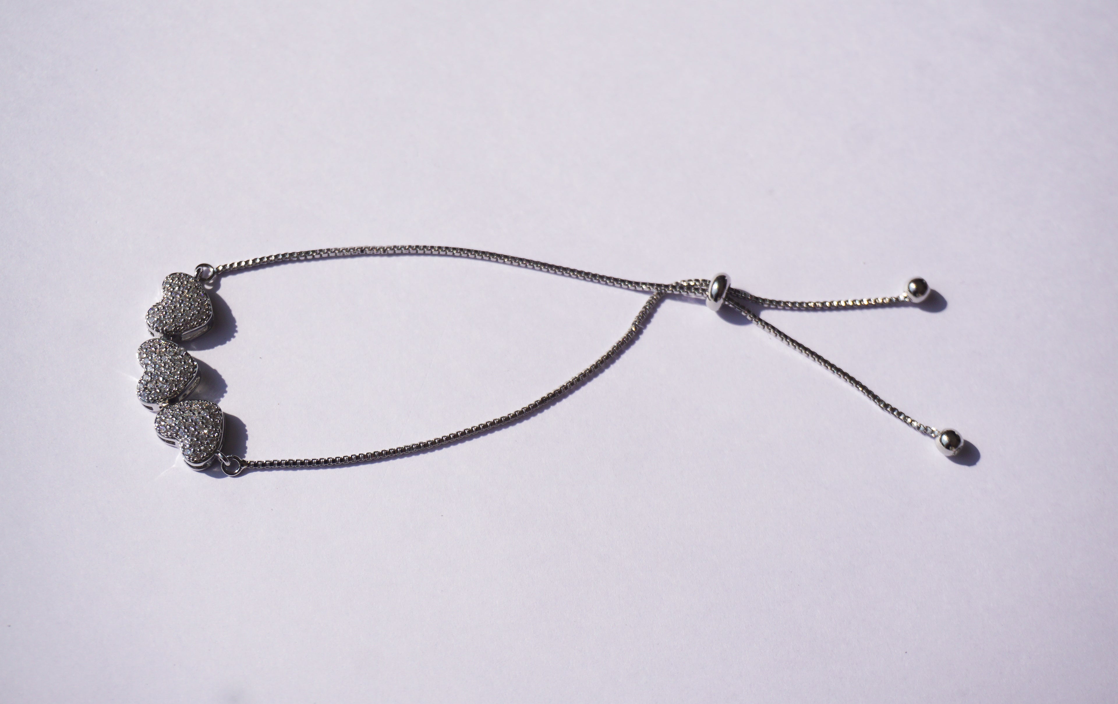 Pulsera plateada con broche ajustable con 3 corazones con zirconias