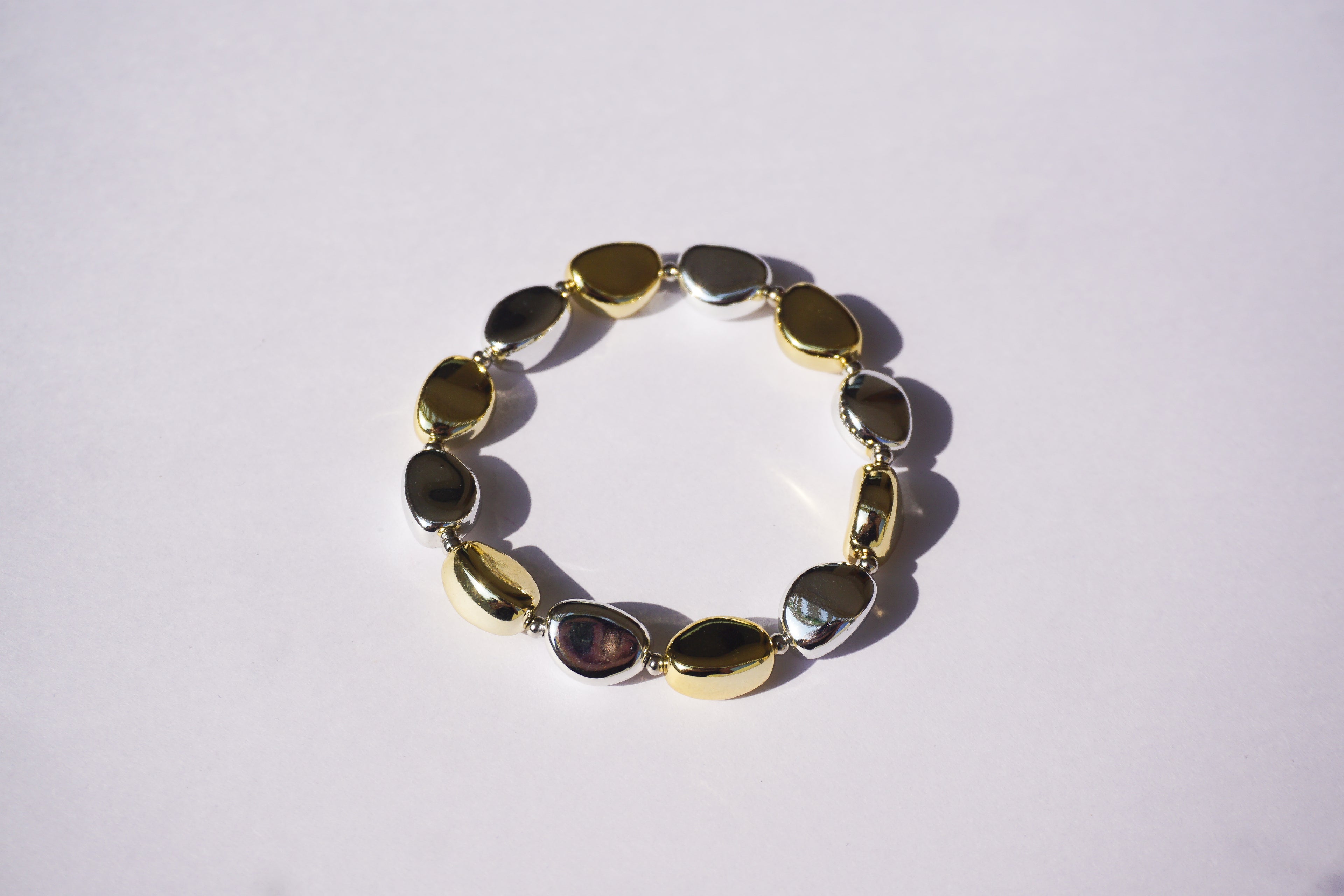 Pulsera de piedras de plástico doradas y plateadas intercaladas