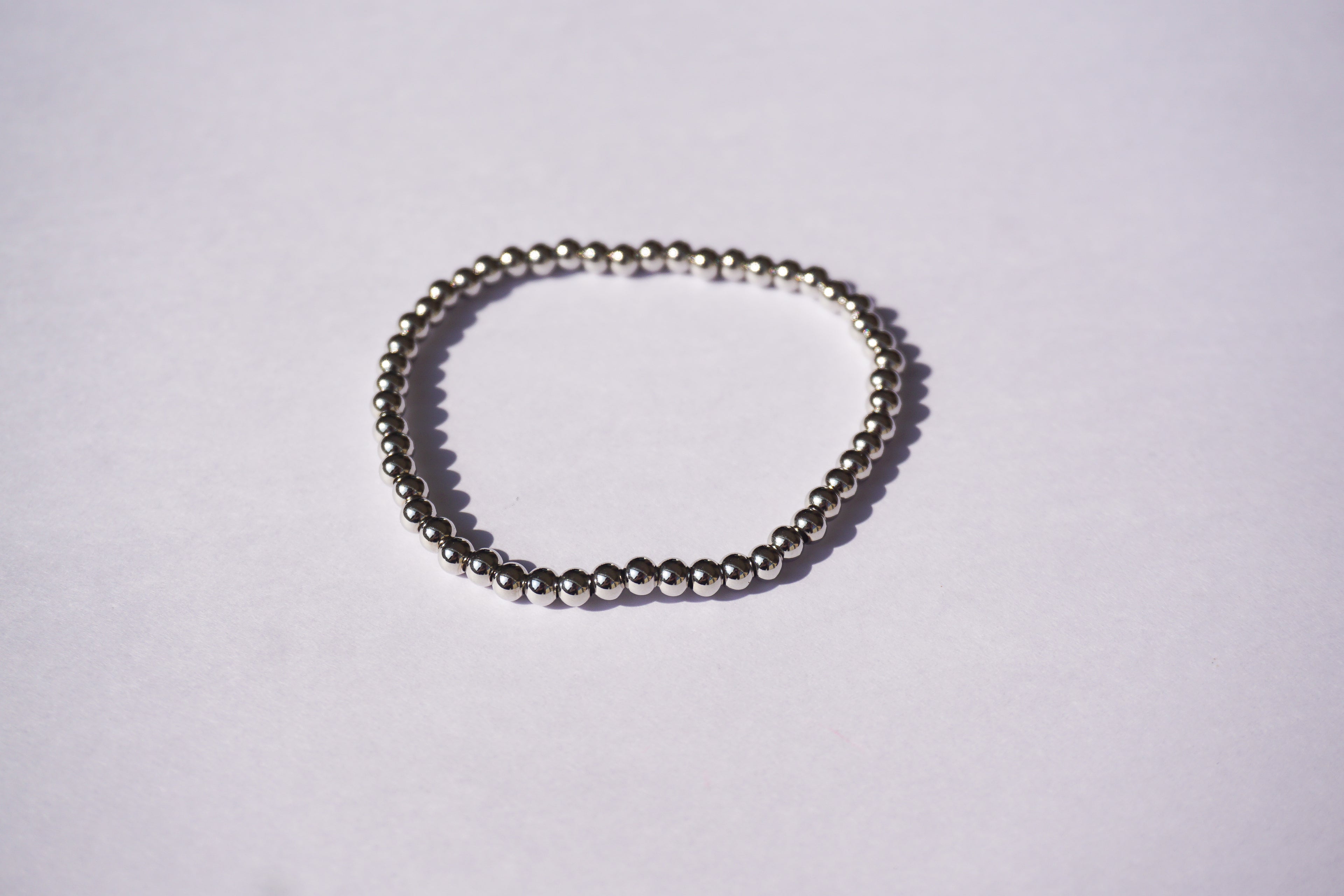 Pulsera con bolita plateada de elástico