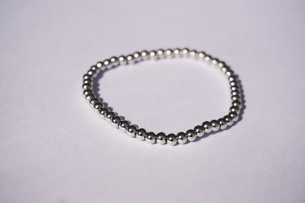 Pulsera con bolita plateada de elástico