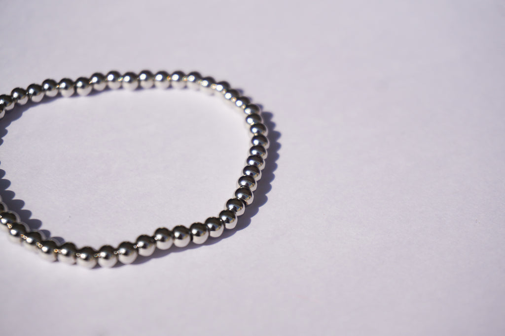 Pulsera con bolita plateada de elástico