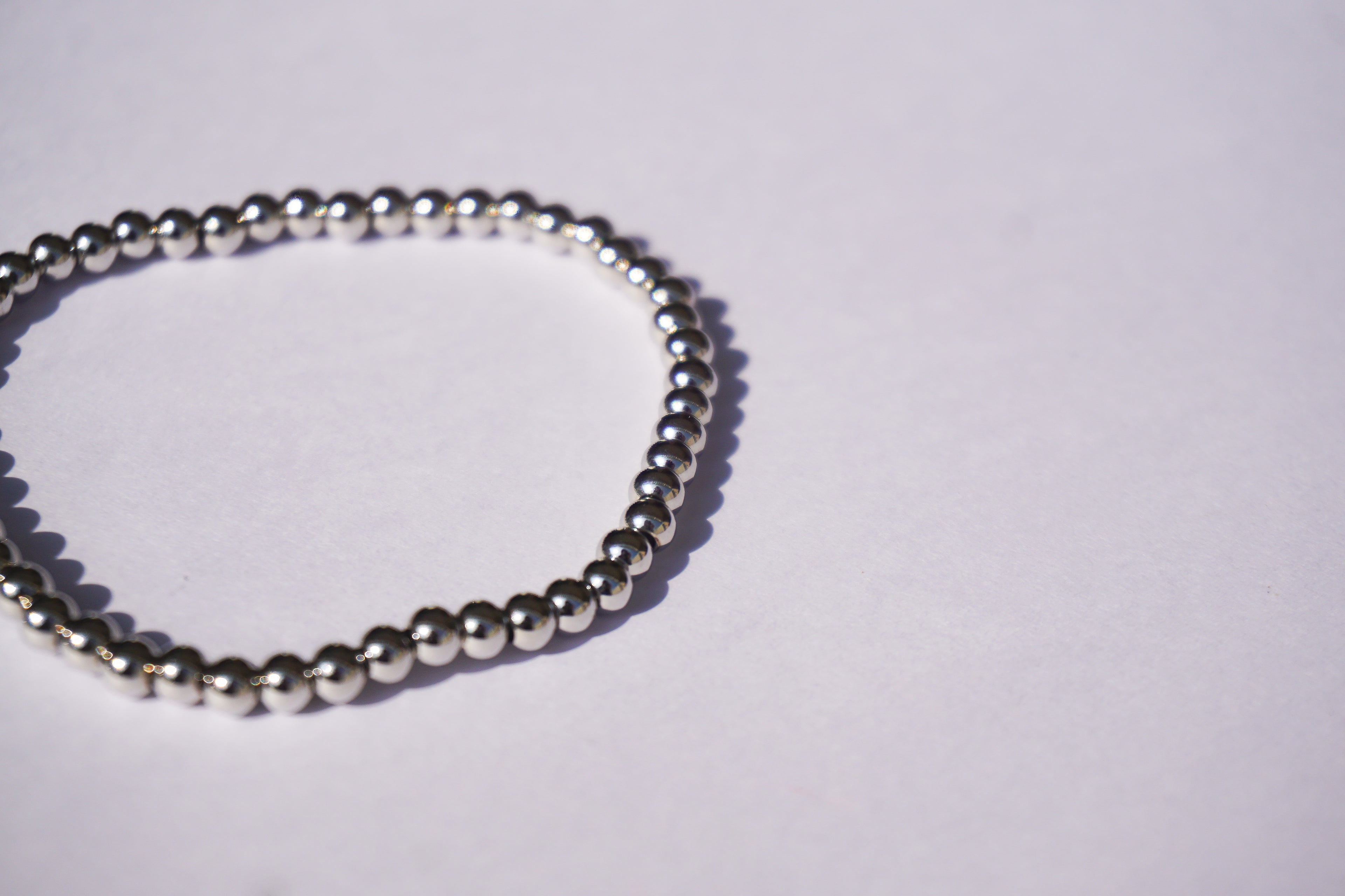 Pulsera con bolita plateada de elástico