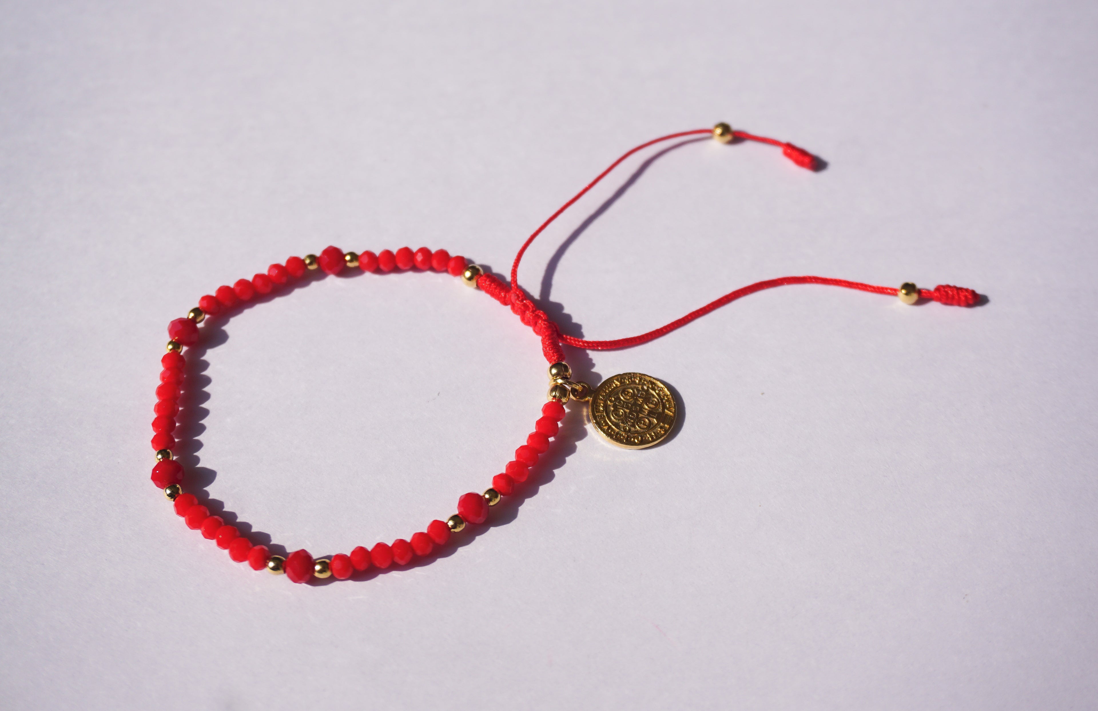 Pulsera de hilo rojo con cristales y San Benito dorado