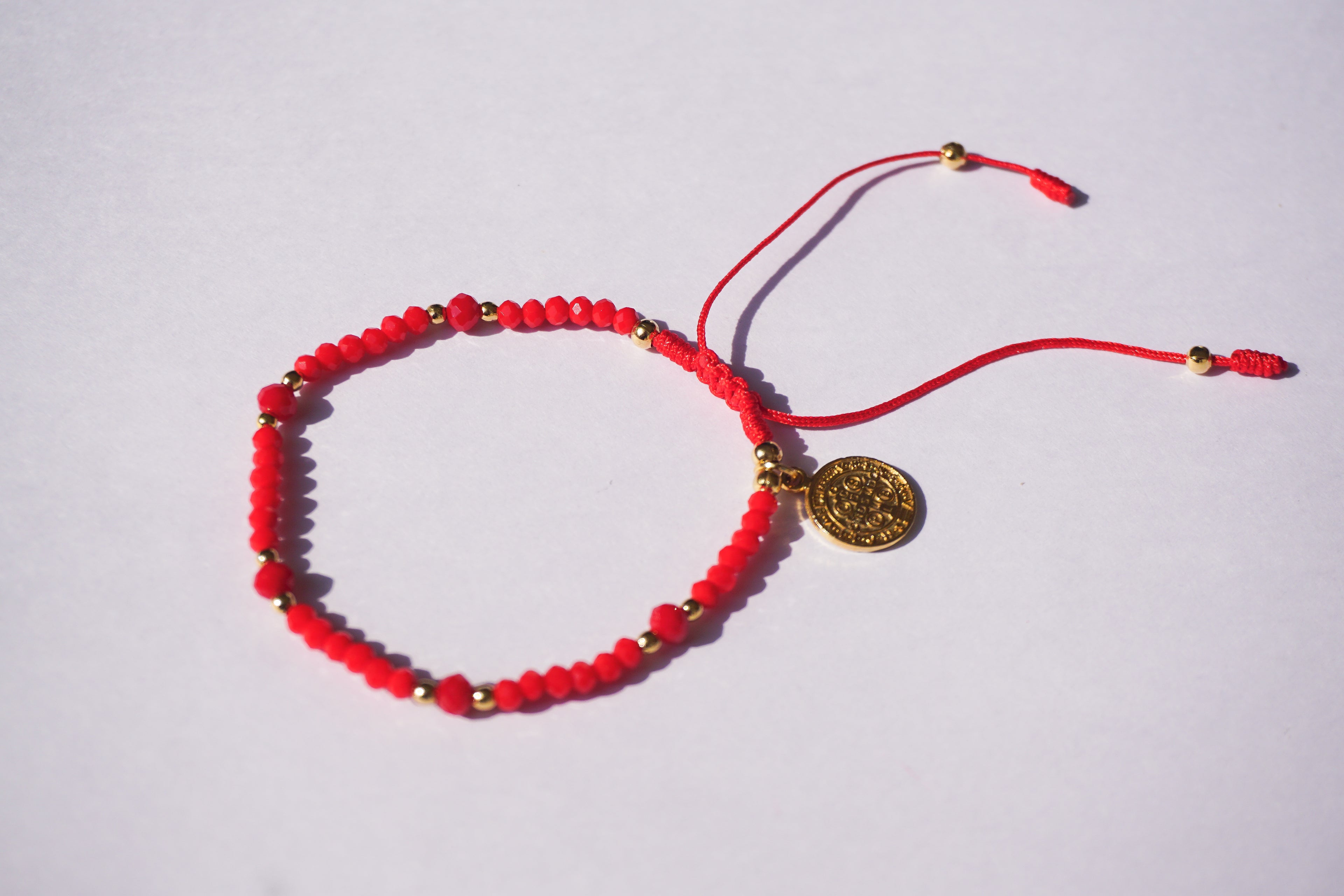 Pulsera de hilo rojo con cristales y San Benito dorado