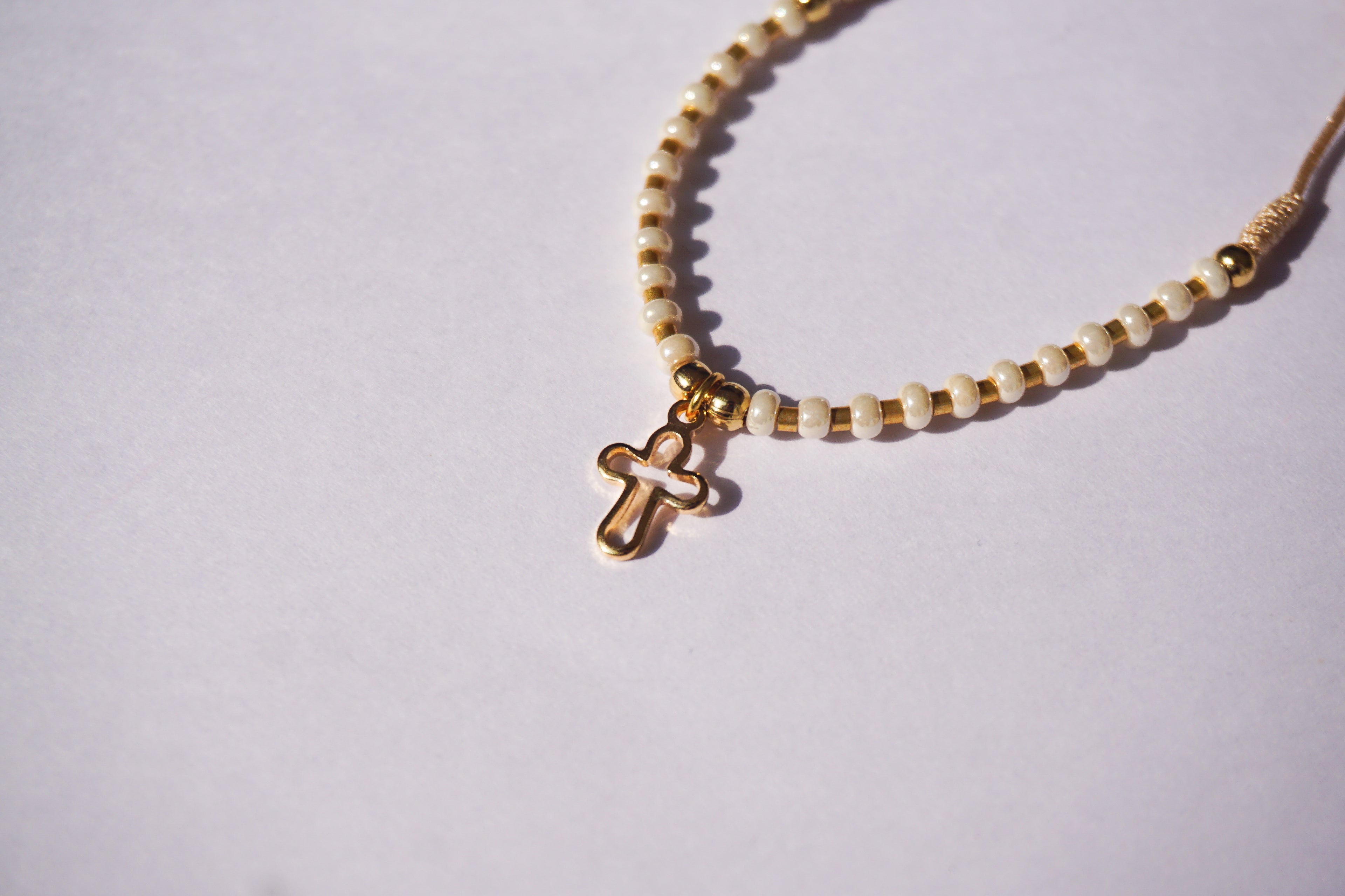 Pulsera de hilo con bolita dorada y chaquira intercalada