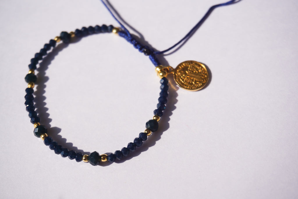 Pulsera de hilo azul con cristales y San Benito dorado