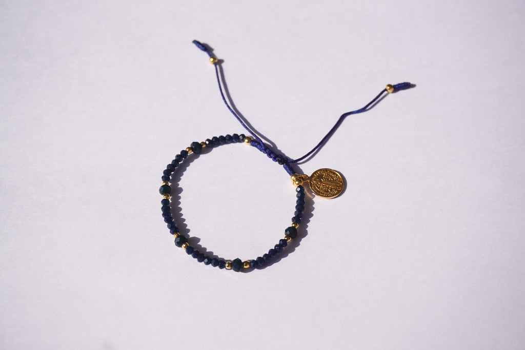 Pulsera de hilo azul con cristales y San Benito dorado