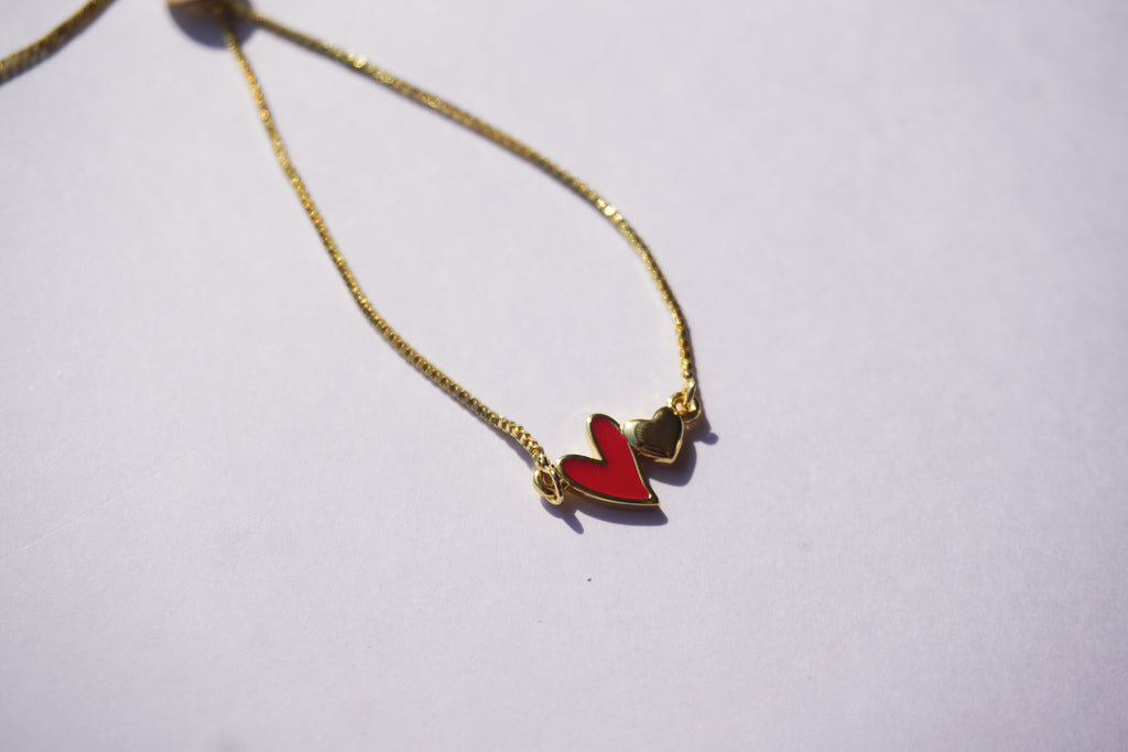 Pulsera dorada con corazón rojo y mini corazón dorado