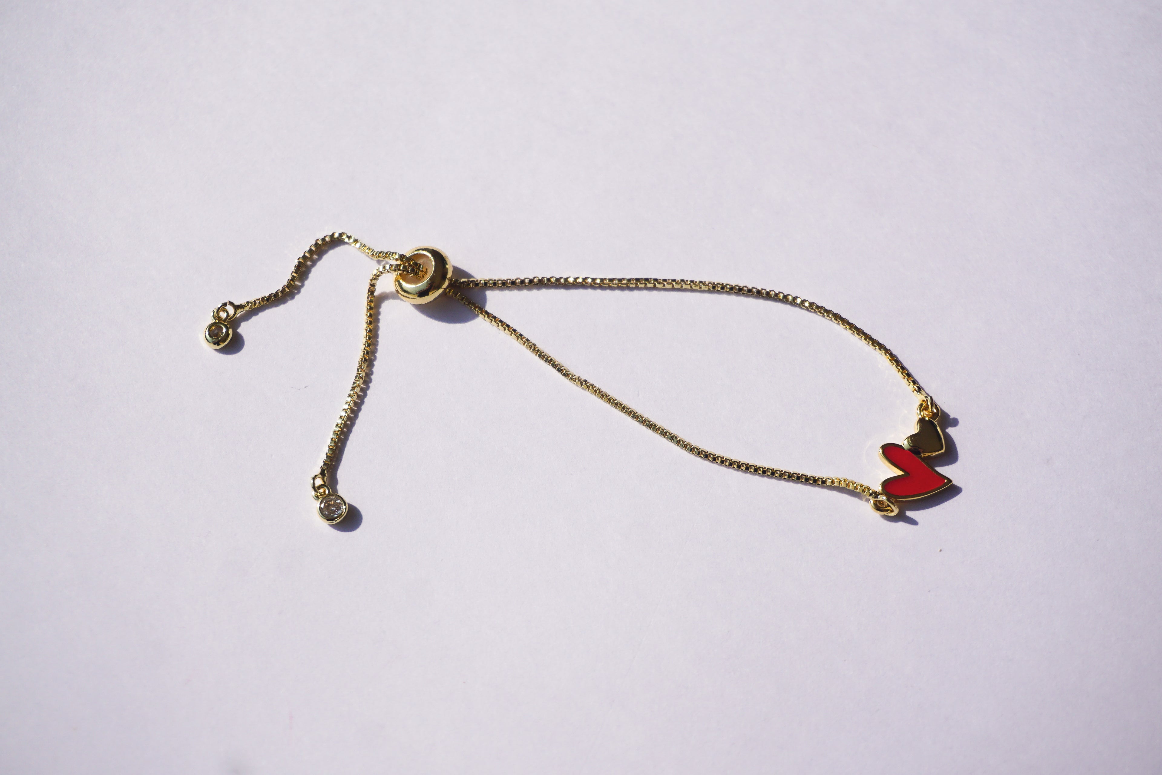 Pulsera dorada con corazón rojo y mini corazón dorado