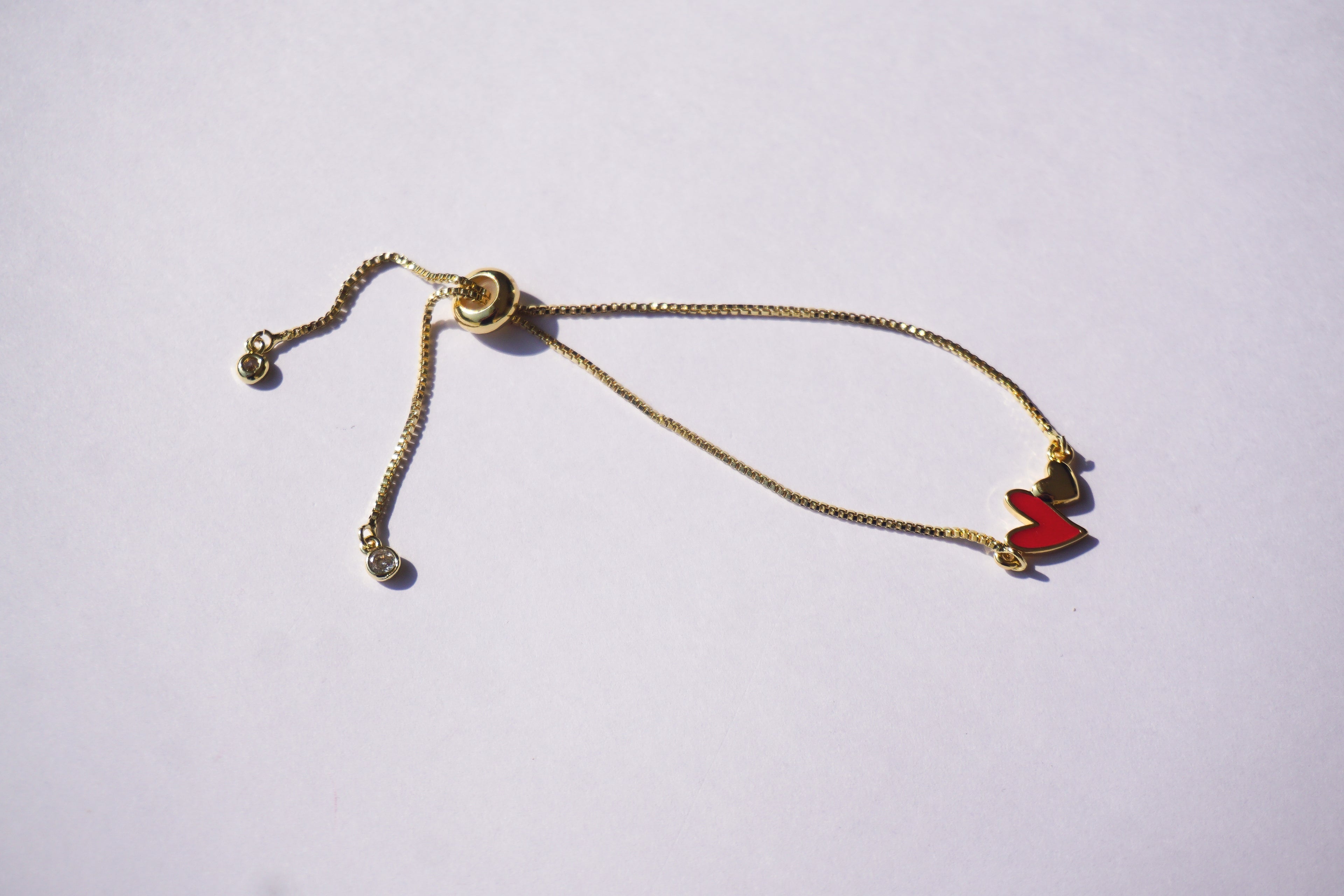 Pulsera dorada con corazón rojo y mini corazón dorado
