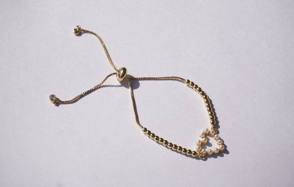 Pulsera dorada con bolitas y corazón de perlitas