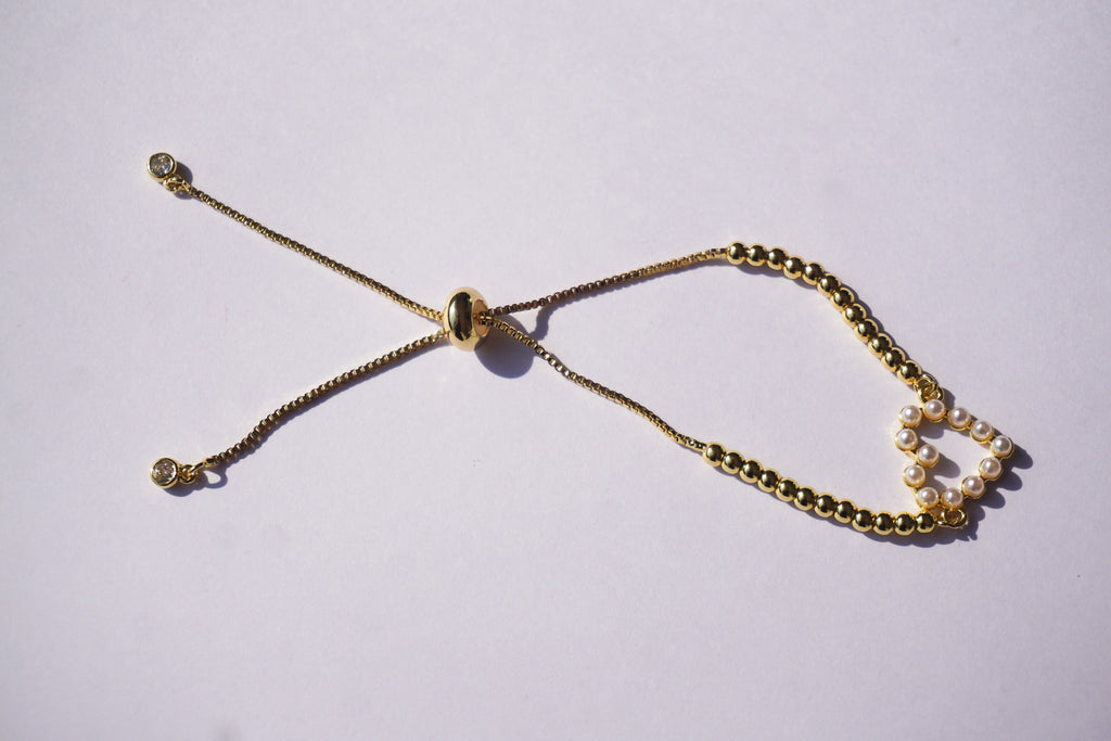 Pulsera dorada con bolitas y corazón de perlitas