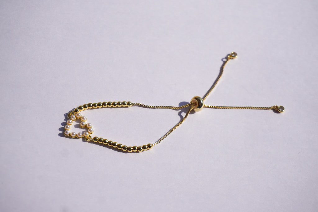 Pulsera dorada con bolitas y corazón de perlitas