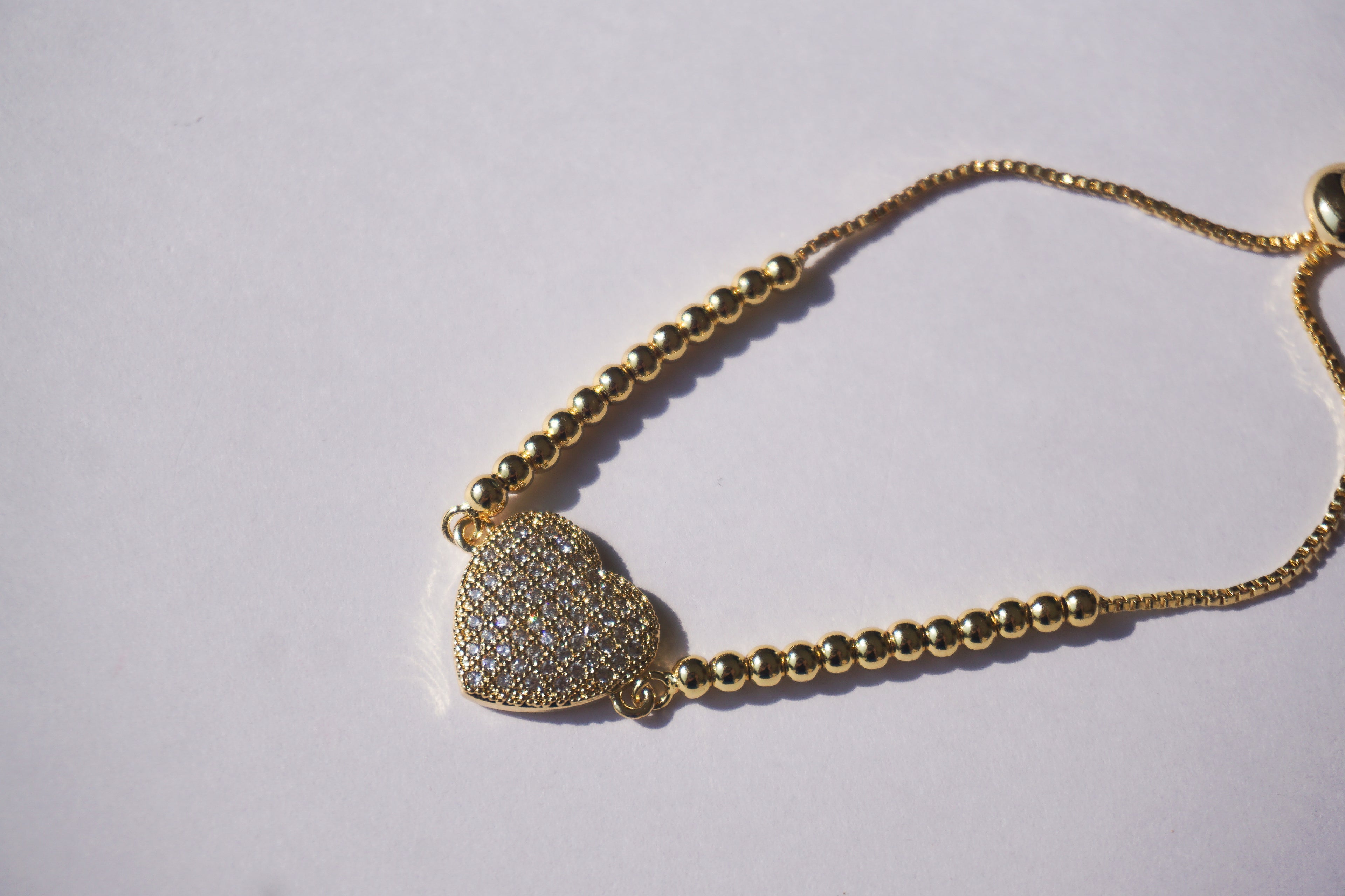 Pulsera dorada de bolitas con corazón de zirconias