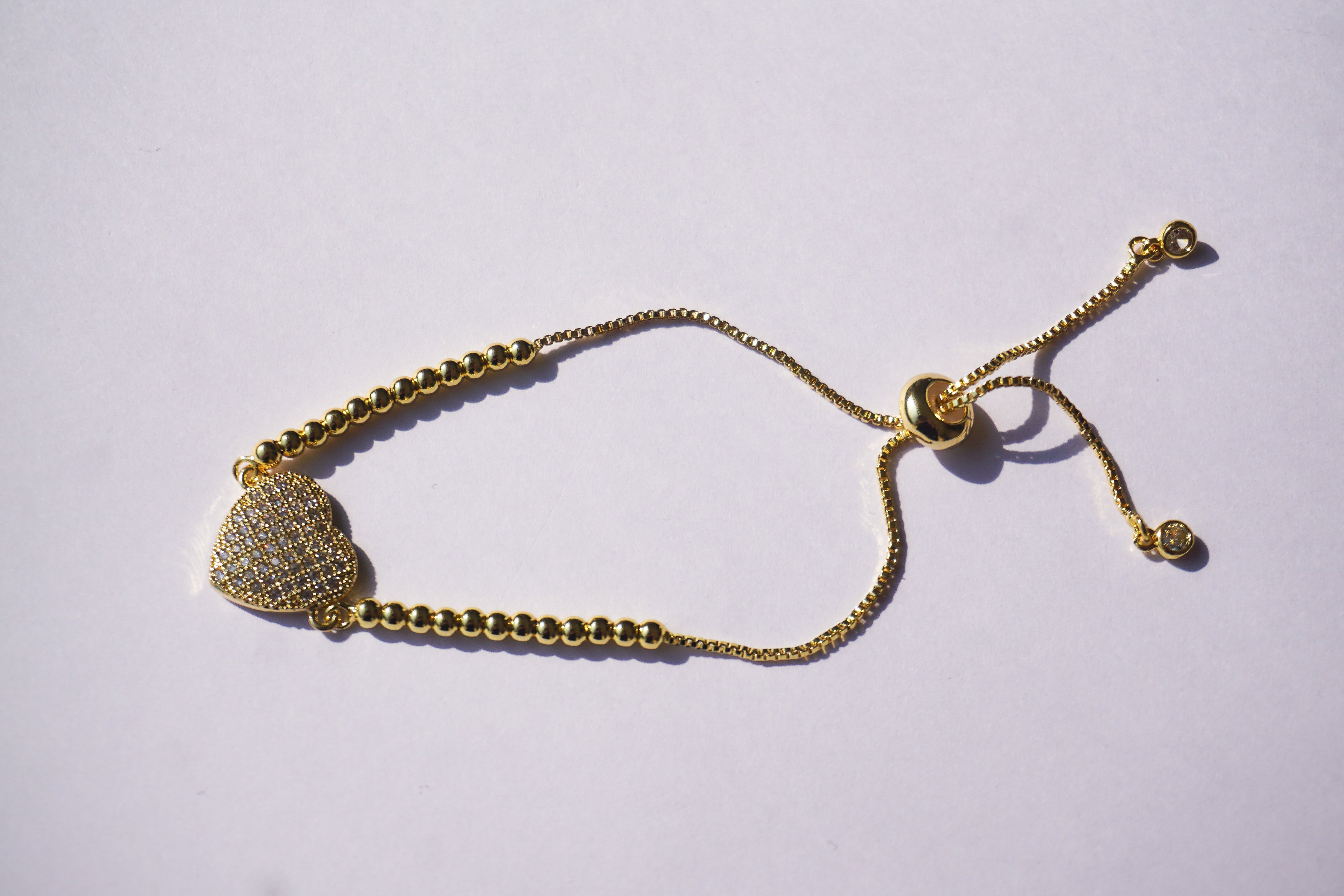 Pulsera dorada de bolitas con corazón de zirconias