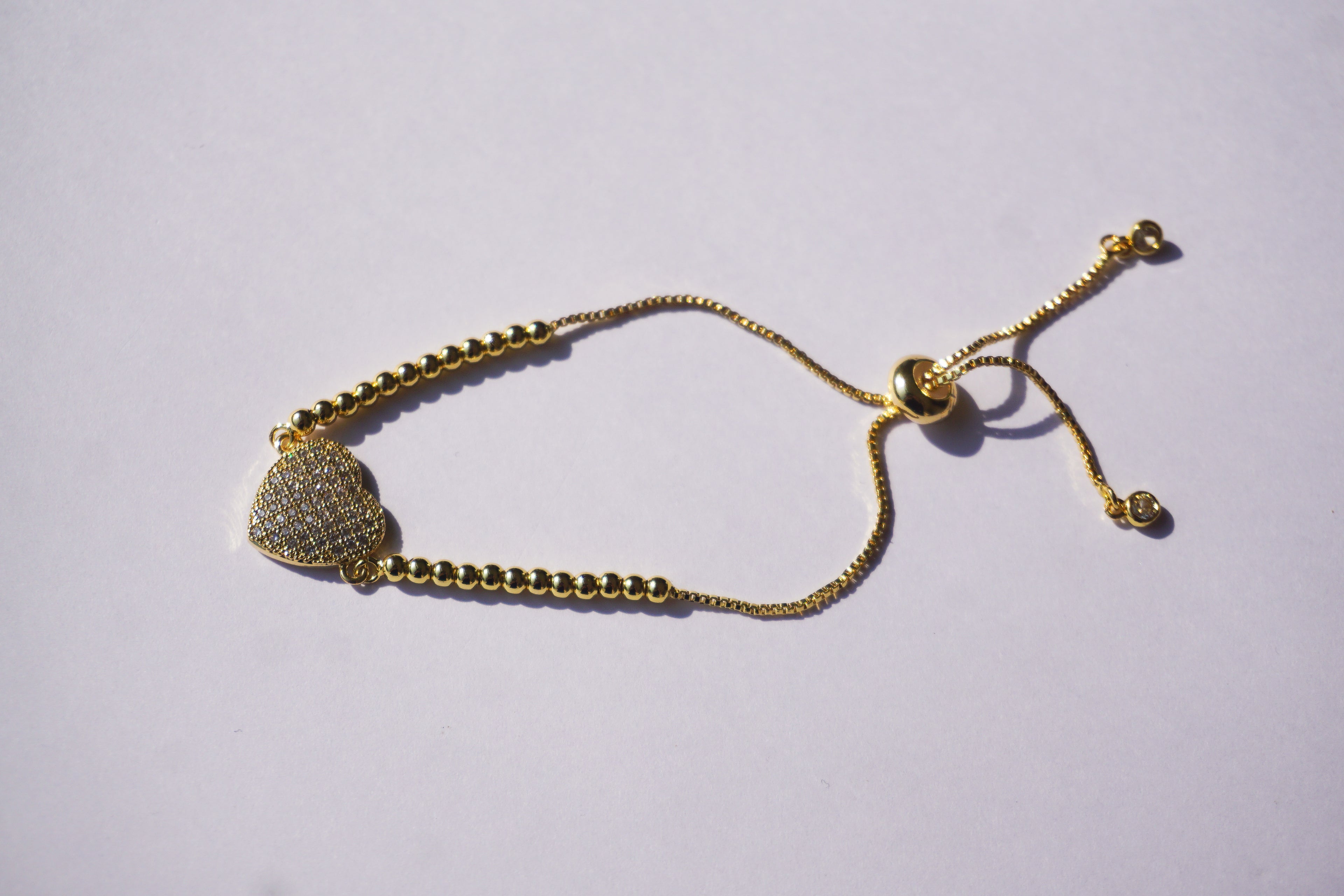Pulsera dorada de bolitas con corazón de zirconias