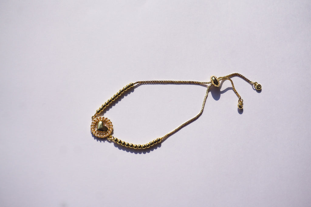 Pulsera dorada con corazón y círculo de perlitas