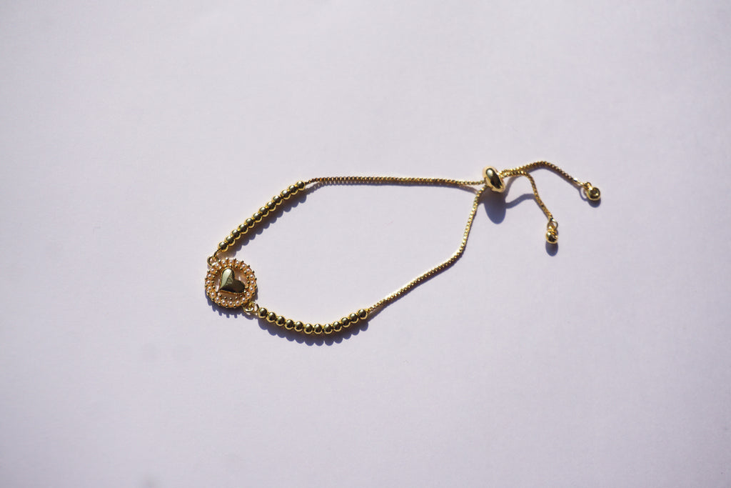 Pulsera dorada con corazón y círculo de perlitas
