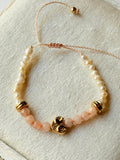 Pulsera de hilo con perlas y cristales rosas con corazón dorado