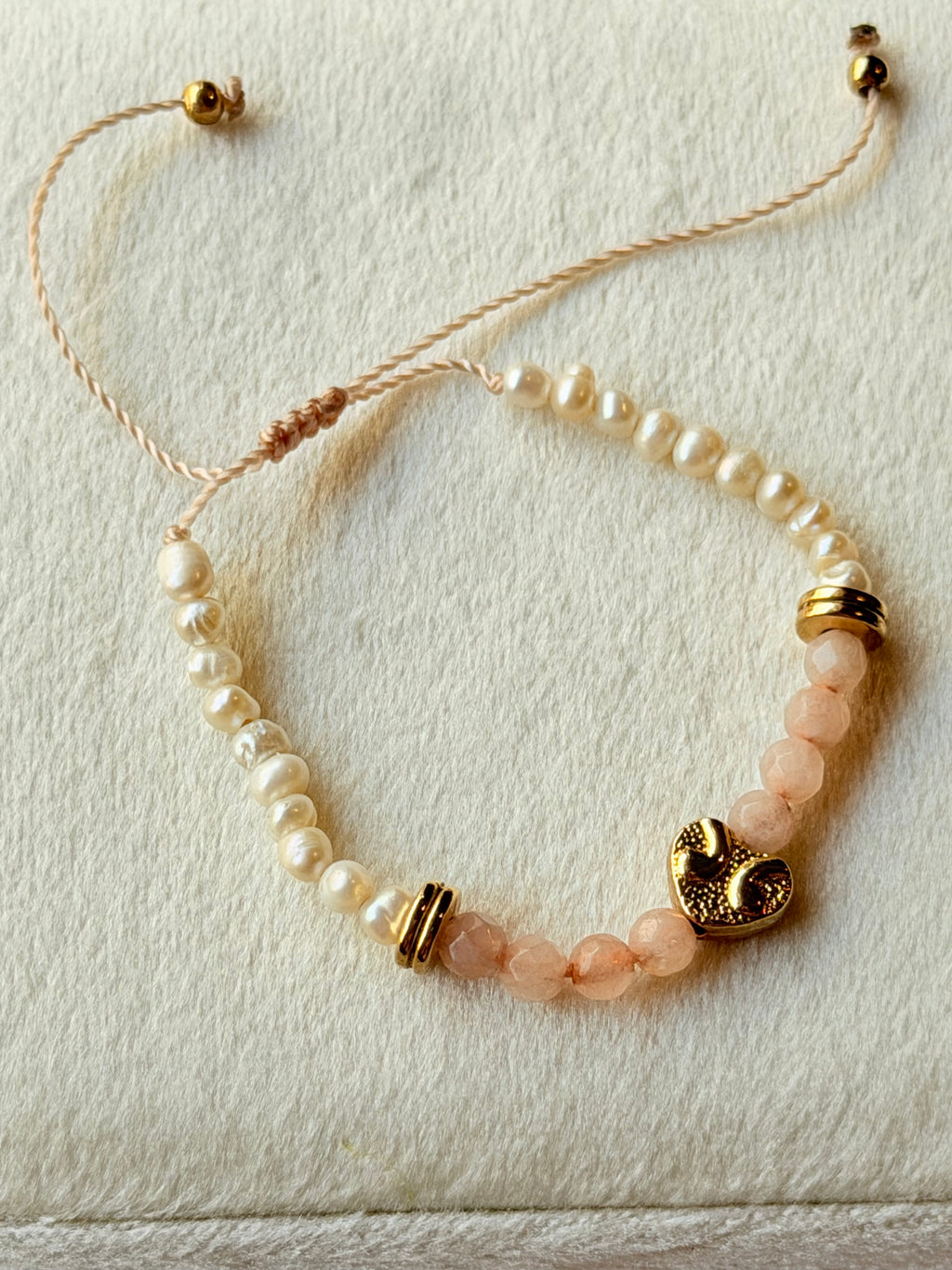Pulsera de hilo con perlas y cristales rosas con corazón dorado