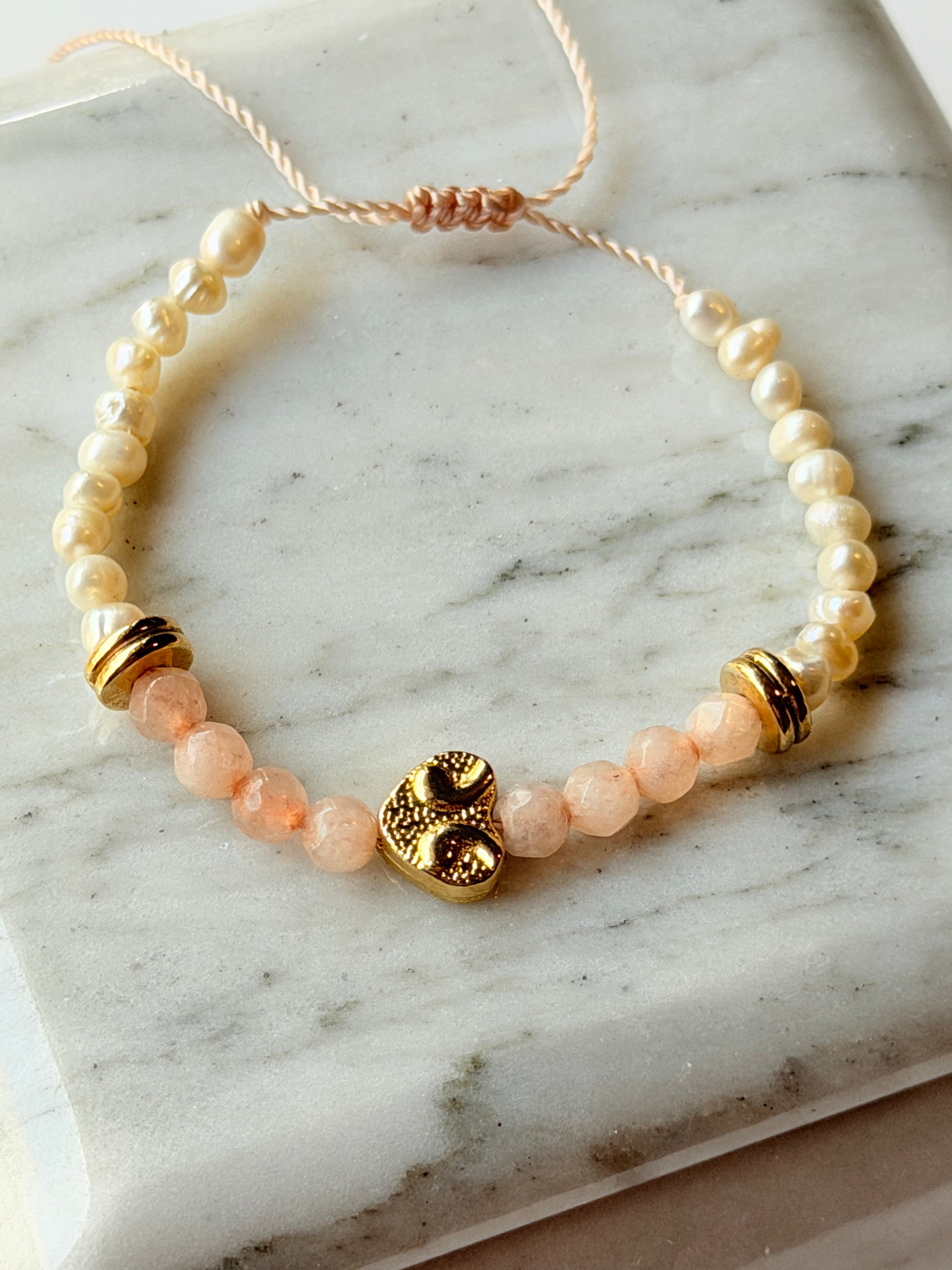 Pulsera de hilo con perlas y cristales rosas con corazón dorado
