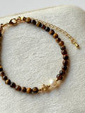 Pulsera de ojo de tigre con perla y cruz